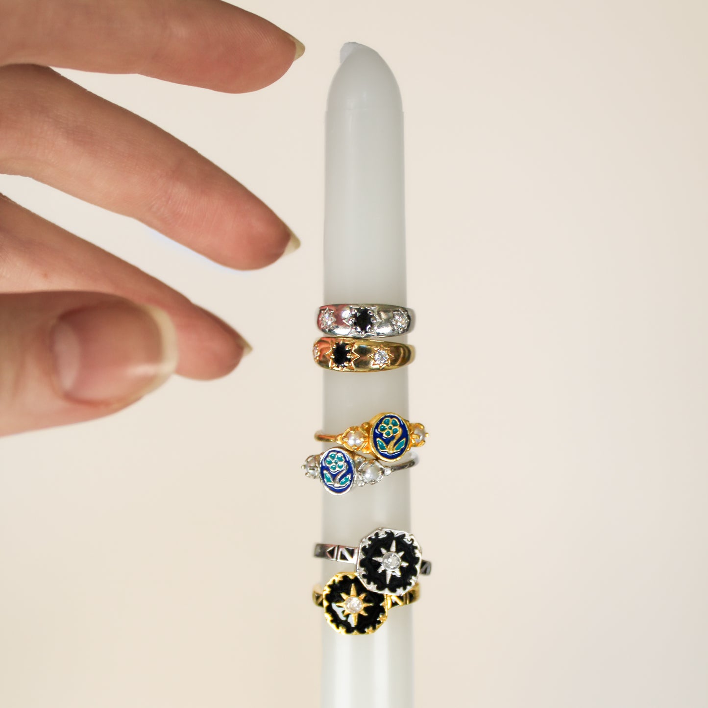 Mourning Bloom ring in sterling silver stacked with other Victorian mourning pieces on candle, Ether Jewelry