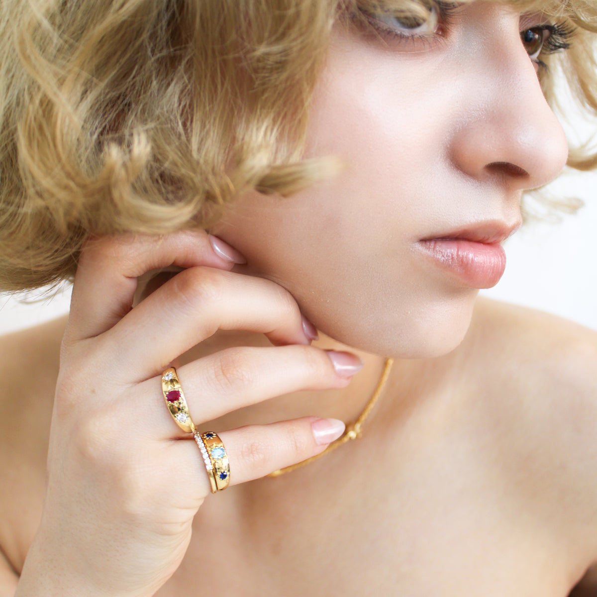 18k gold vermeil Letters from Roma Ring close-up on model hand, three stone gypsy set domed band, Ether Jewelry