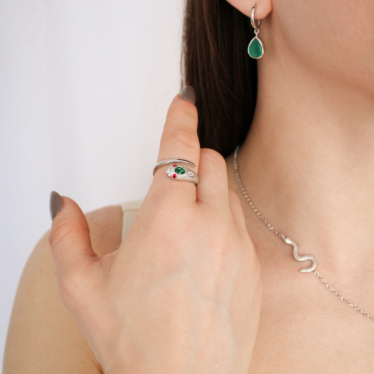 Queen Victoria snake ring in sterling silver on model hand, styled with devoted drop green onyx earrings, model shot, Ether Jewelry