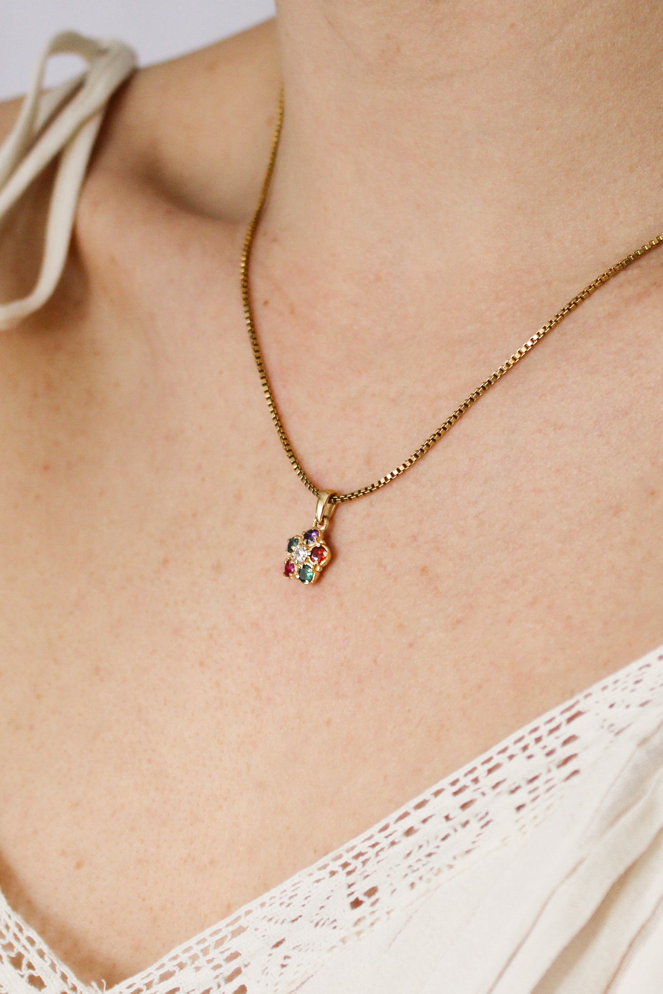 Regard Bloom 18k gold vermeil necklace on model side view, acrostic floral CZ cluster pendant, Ether Jewelry