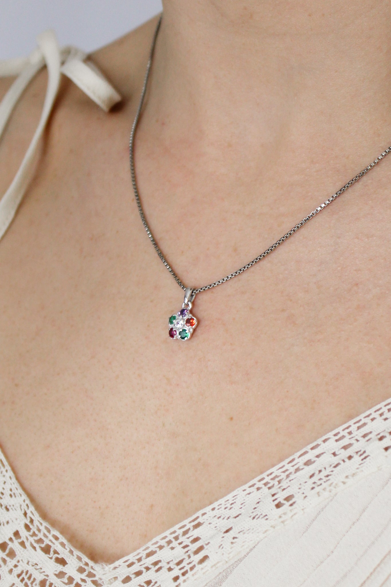Regard Bloom sterling silver necklace on model side view, acrostic floral CZ cluster pendant, Ether Jewelry