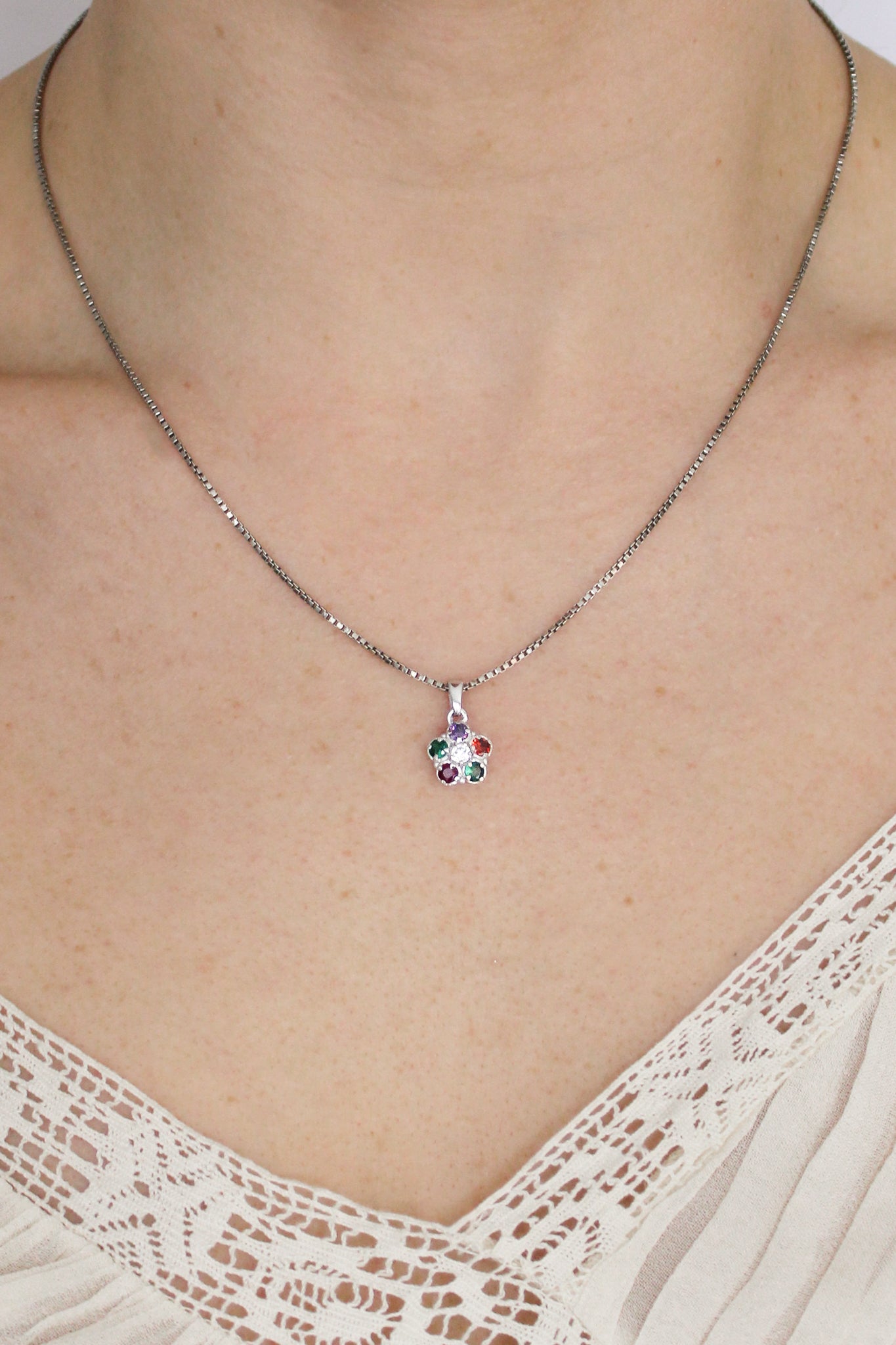Sterling silver Regard Bloom Necklace front view on model, colorful REGARD acrostic floral pendant on box chain, Ether Jewelry