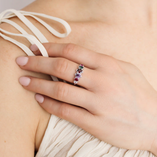 Crowned Jewel Ring in sterling silver worn on model hand on chest in beige dress, oval REGARD acrostic CZ ring, Ether Jewelry