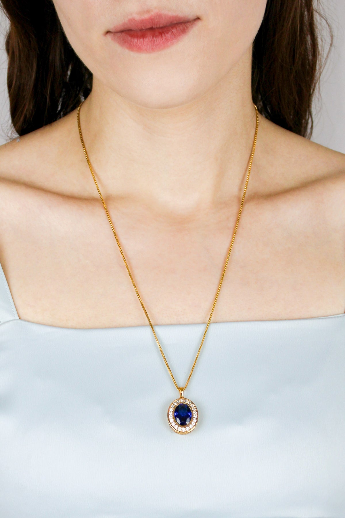 Model wearing Heartline Necklace in gold, sapphire gemstone resting elegantly at collarbone — inspired by Princess Diana’s grace, Ether Jewelry