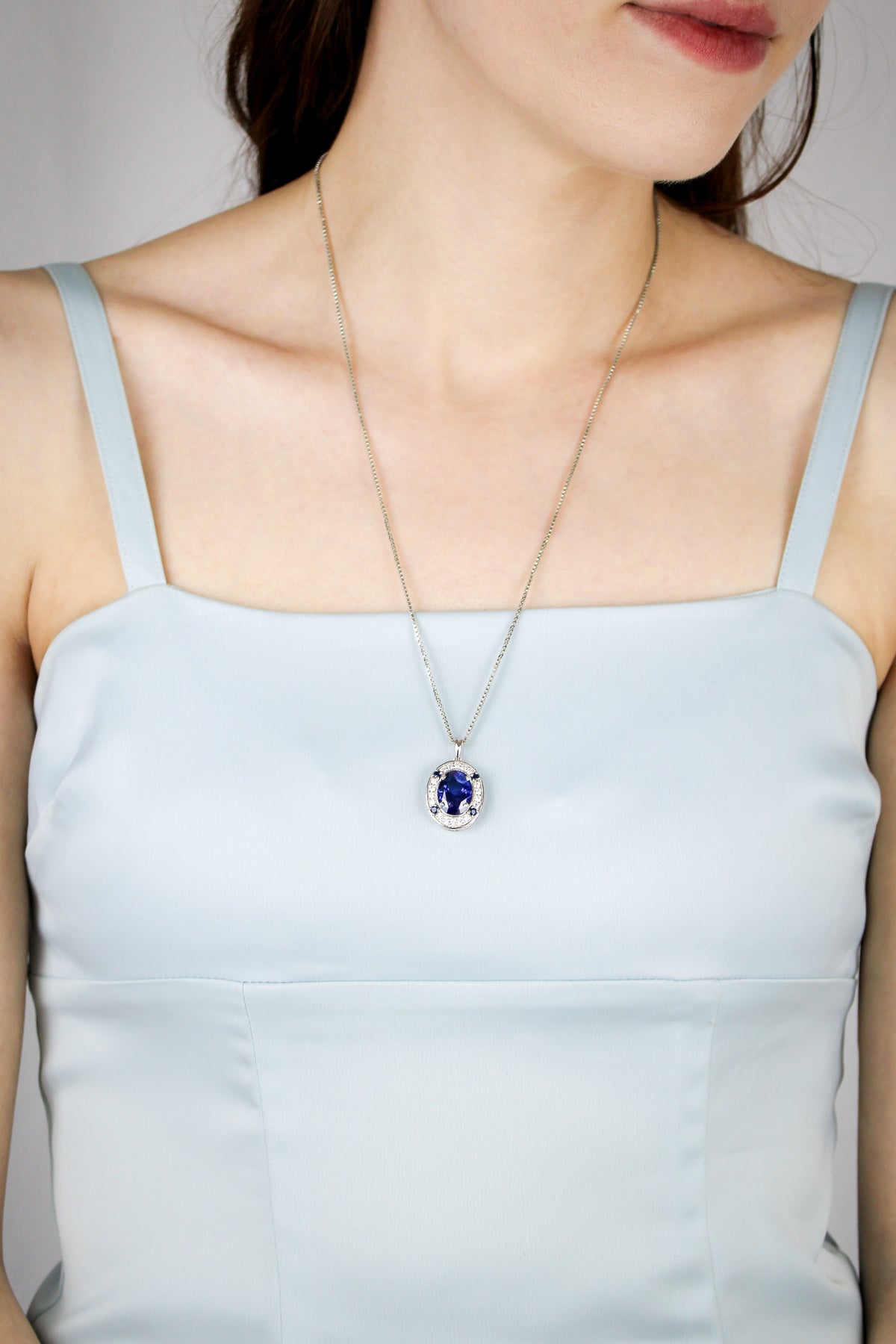 Model wearing silver Heartline Necklace with sapphire gemstone, embodying Princess Diana’s effortless poise, Ether Jewelry