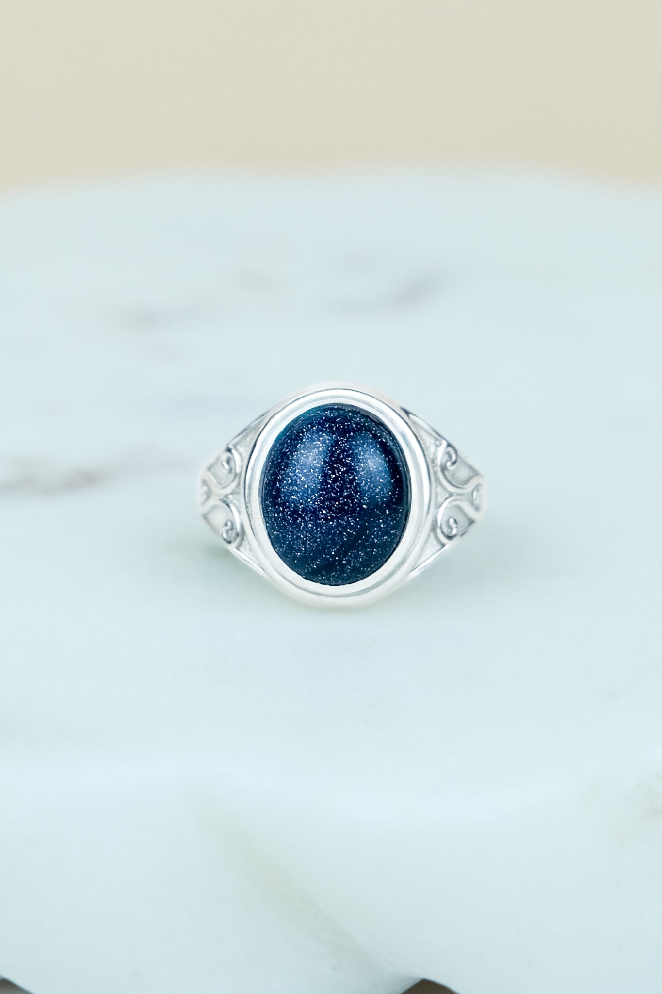sterling Silver night keeper signet ring with a blue sandstone gemstone on a marble background