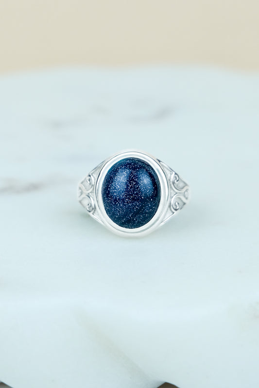 sterling Silver night keeper signet ring with a blue sandstone gemstone on a marble background