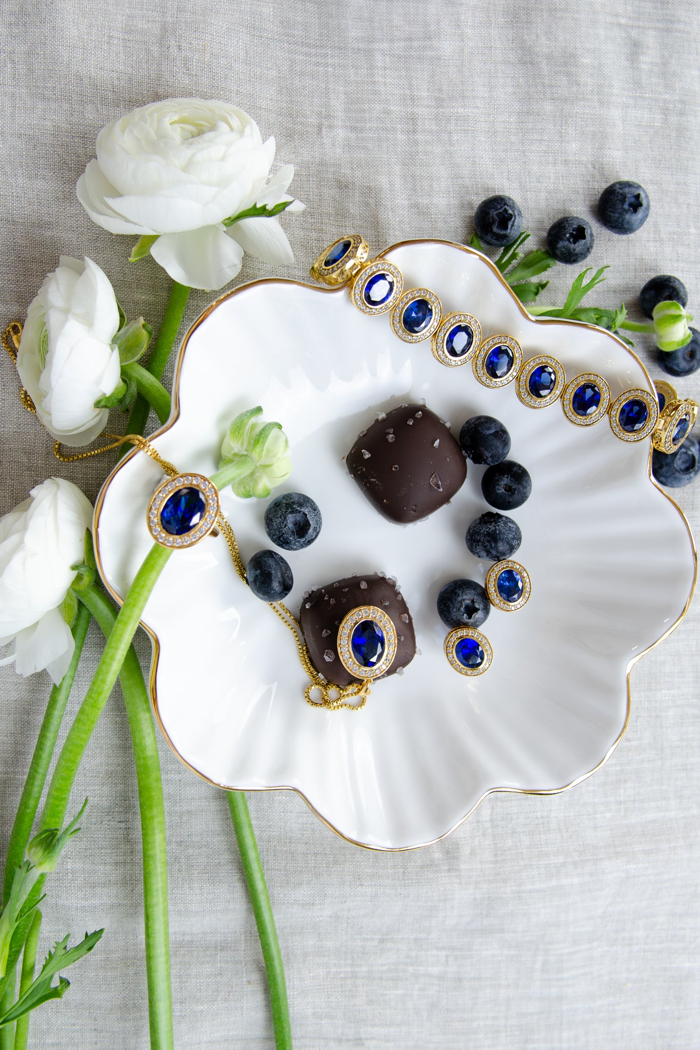 Flat lay of The Diana Legacy Collection by Ether Jewelry — gold rings, necklaces, bracelets, and earrings inspired by Princess Diana’s timeless grace and royal elegance.