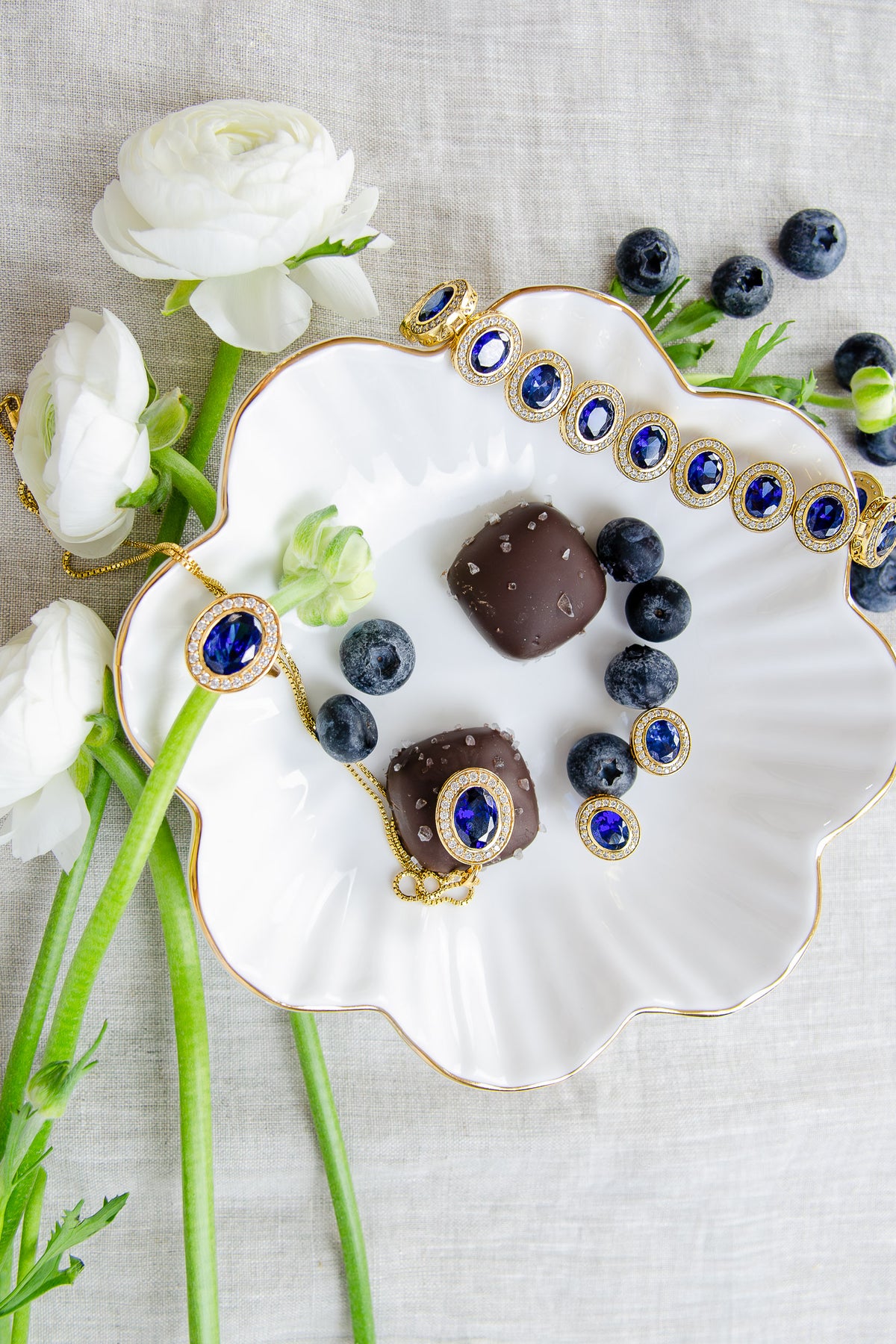 Styled group photo showcasing the complete Diana Legacy Collection, blending sapphire gemstones, gold vermeil to celebrate love, legacy, and light, Ether Jewelry