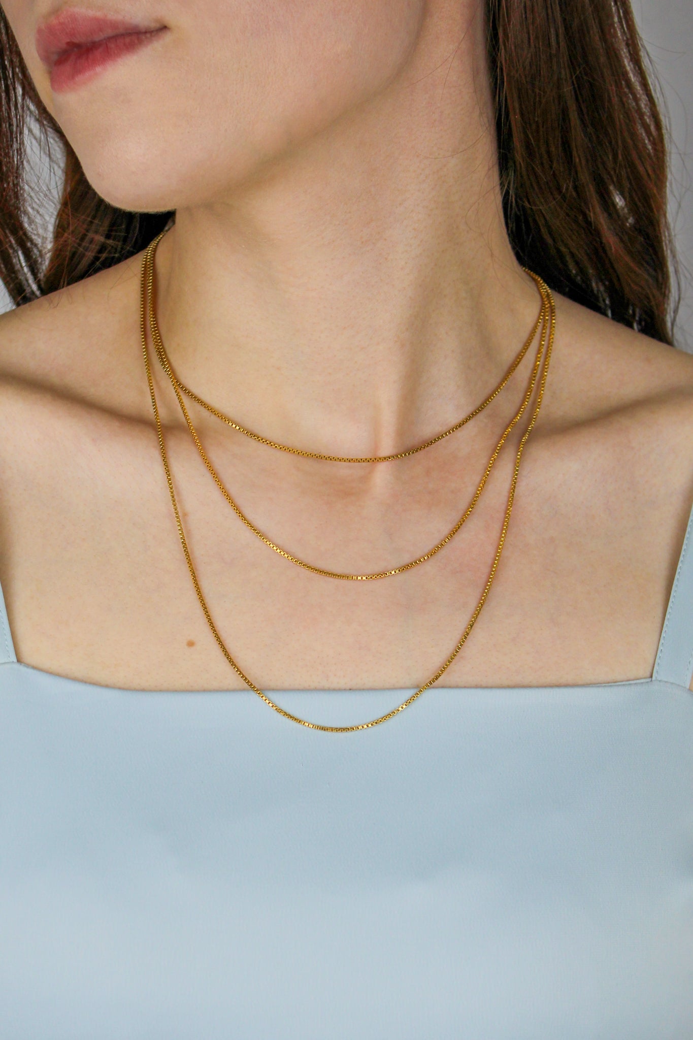 Gold Necklace styled on model layered with other Ether pieces for a modern royal look.
