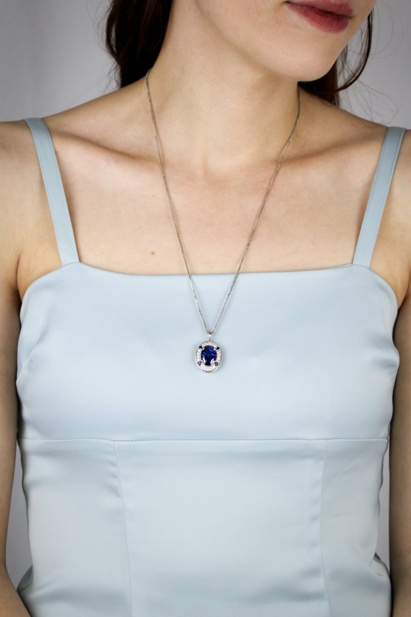 Model wearing silver Heartline Necklace with sapphire gemstone, embodying Princess Diana’s effortless poise, Ether Jewelry