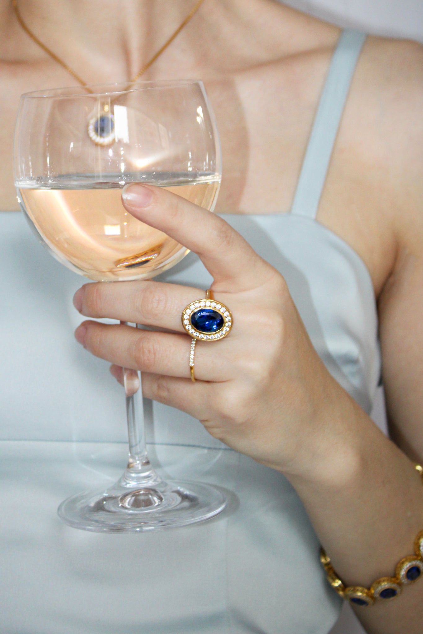 Model gently holding wine glass while wearing gold Legacy Ring, evoking Princess Diana’s elegance and quiet strength, Ether Jewelry.
