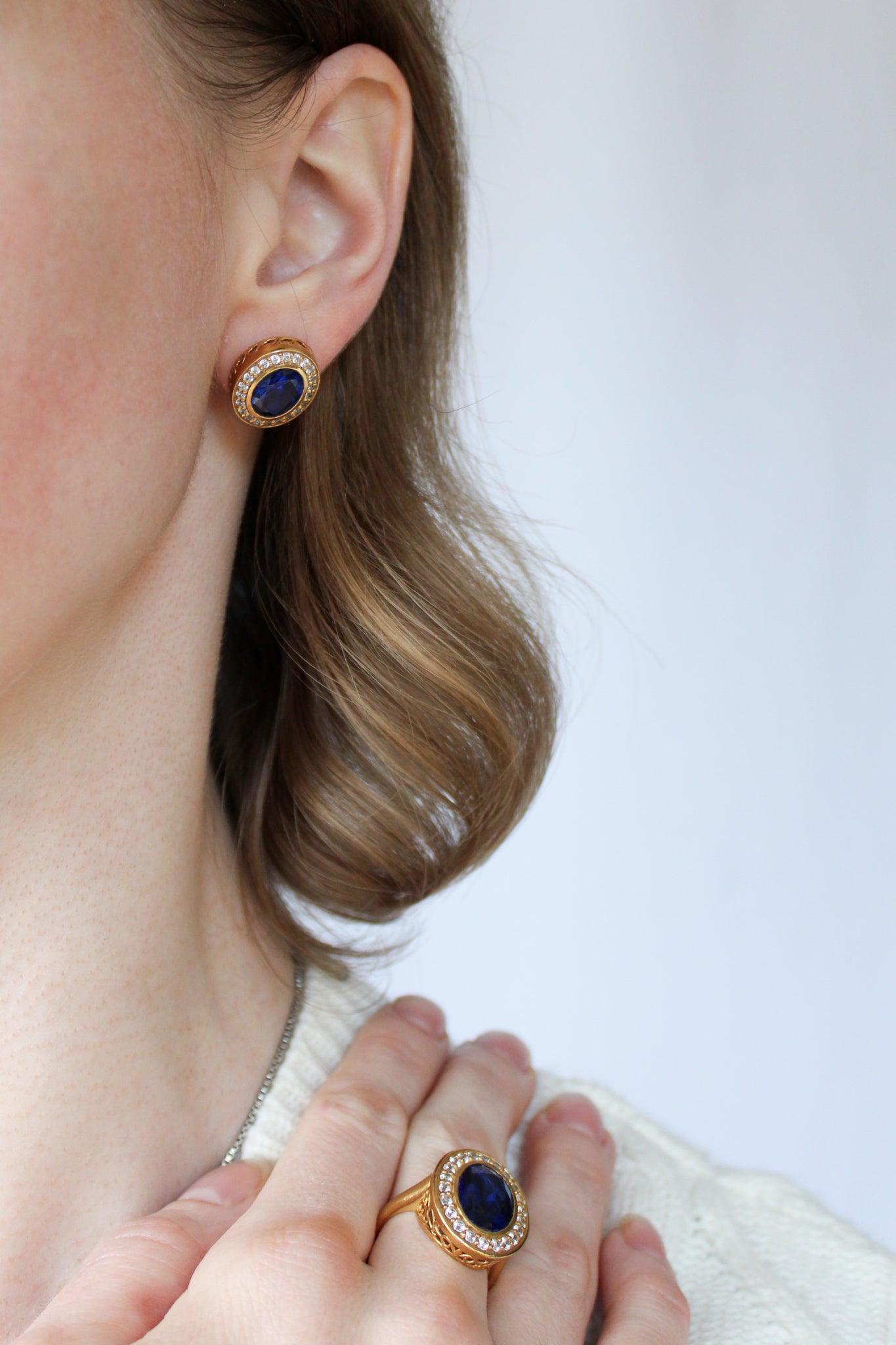 Profile shot of model wearing gold Sovereign Studs, luminous halos symbolizing modern royalty.