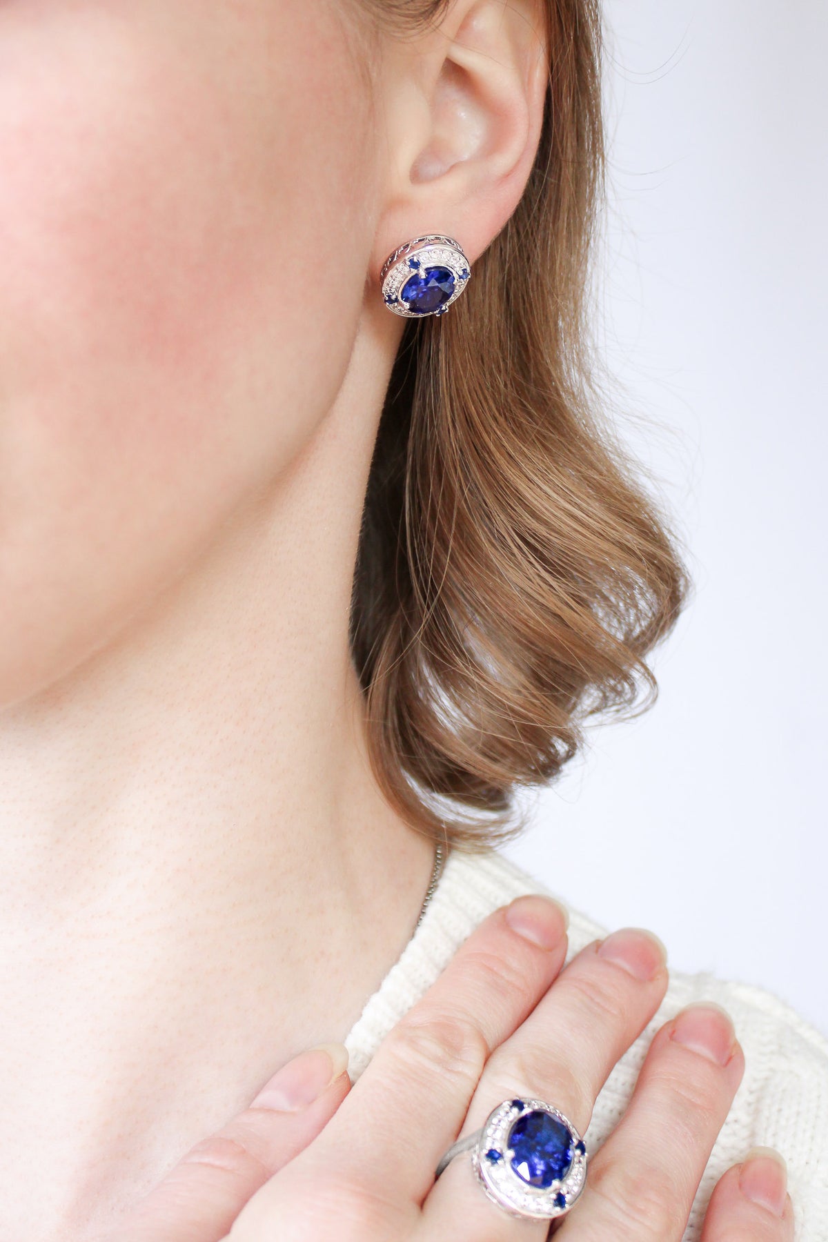 Model with loose waves wearing silver Sovereign Studs, evoking quiet confidence and beauty, Ether Jewelry