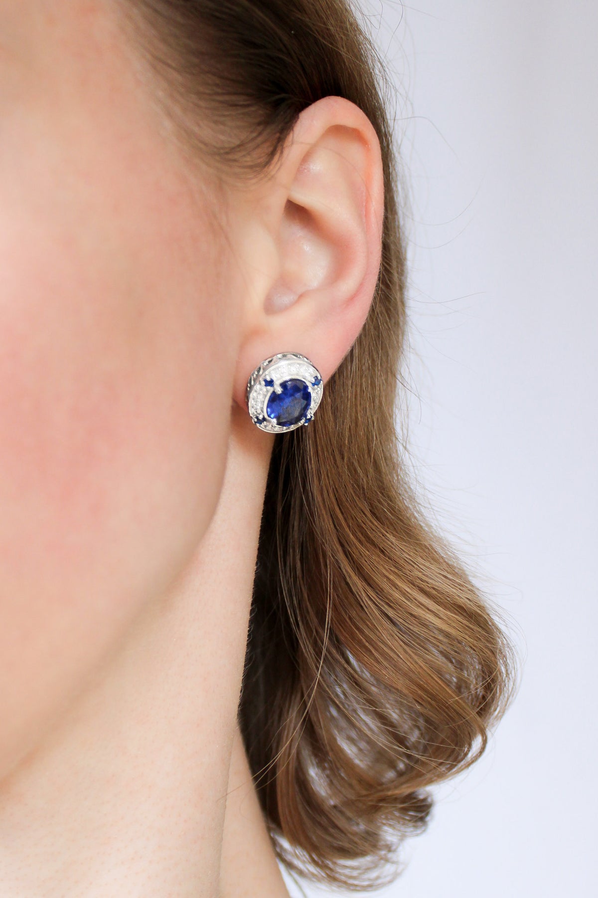 Model portrait highlighting silver Sovereign Stud Earrings, radiant blue gemstones symbolizing grace and remembrance, Ether Jewelry