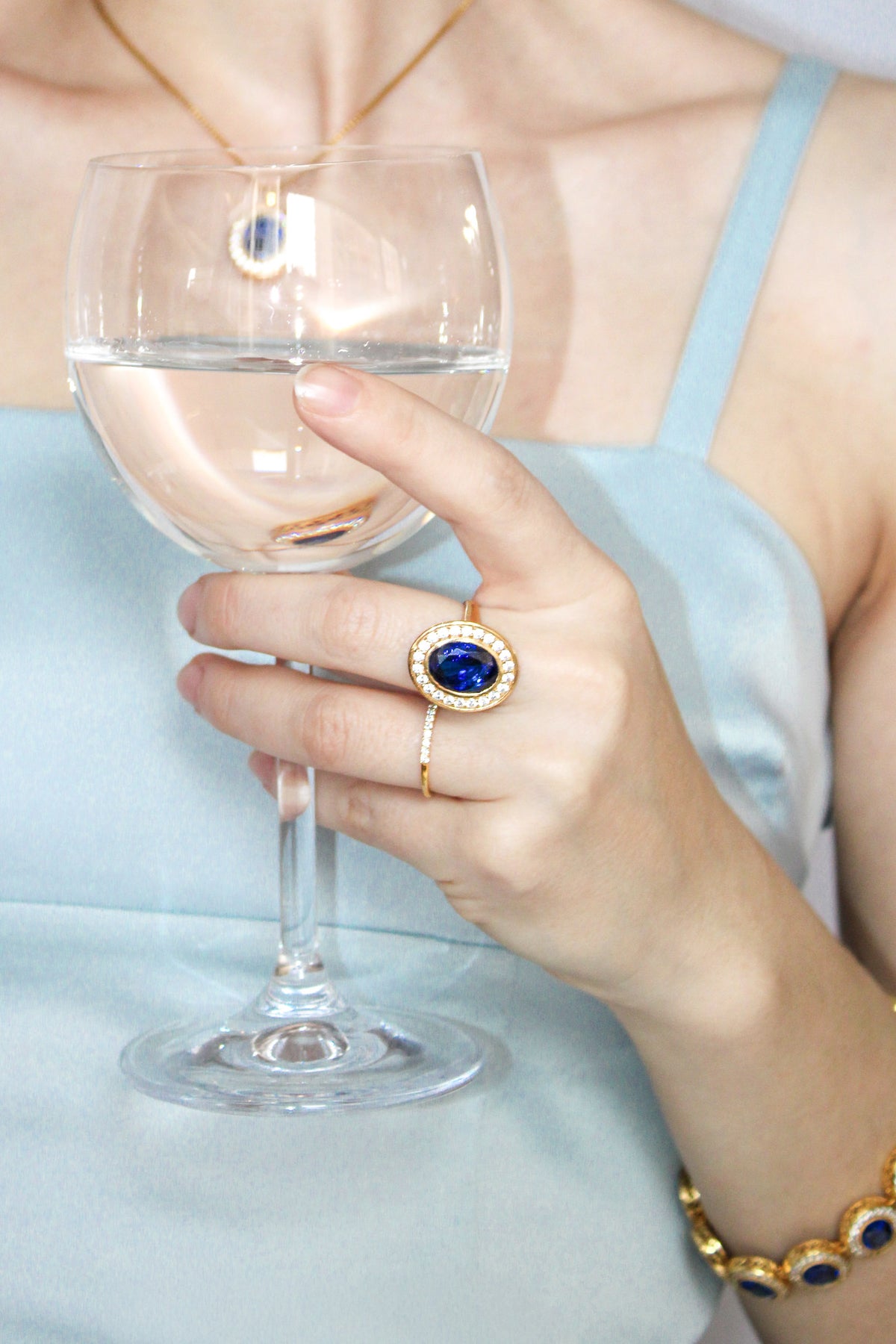 Model gently holding wine glass while wearing gold Legacy Ring, evoking Princess Diana’s elegance and quiet strength, Ether Jewelry.
