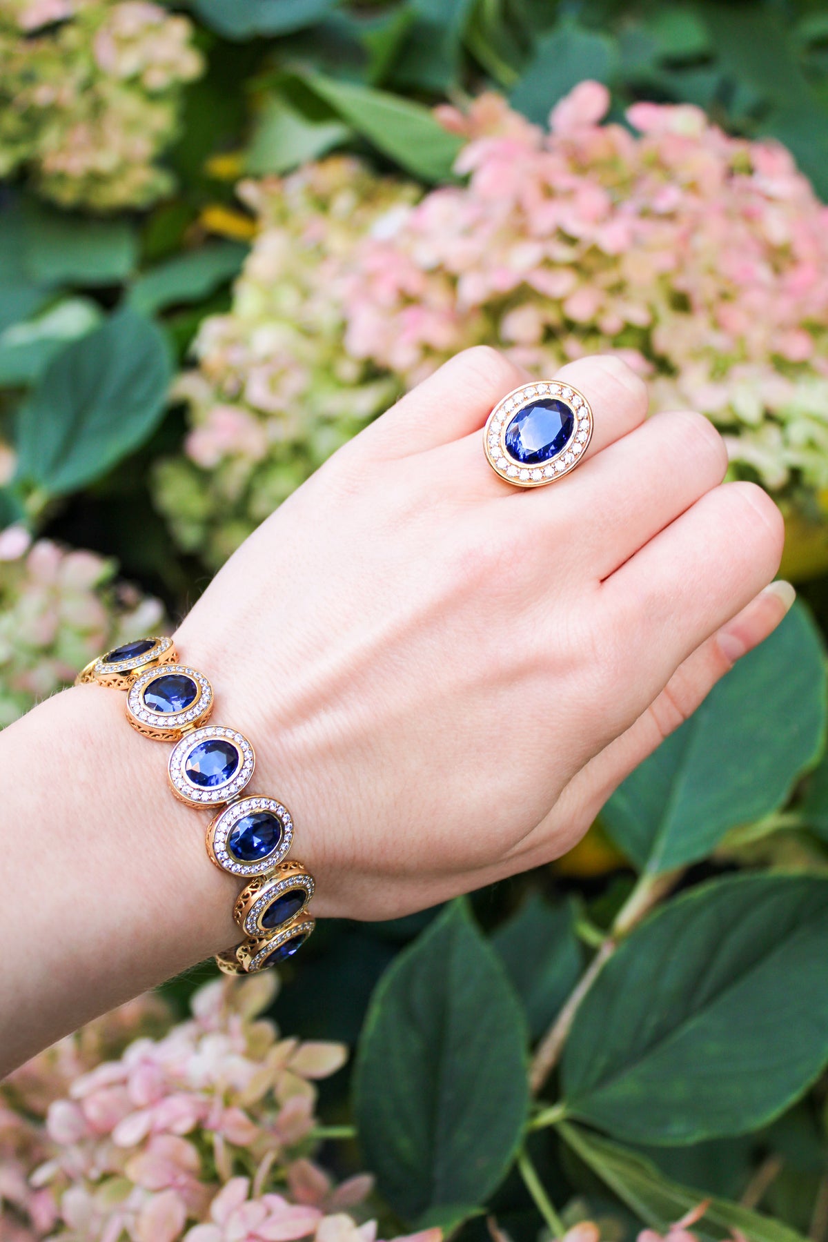 Model wearing The Legacy Ring in gold vermeil with sapphire-toned center gemstone catching warm light — inspired by Princess Diana’s timeless grace, Ether Jewelry