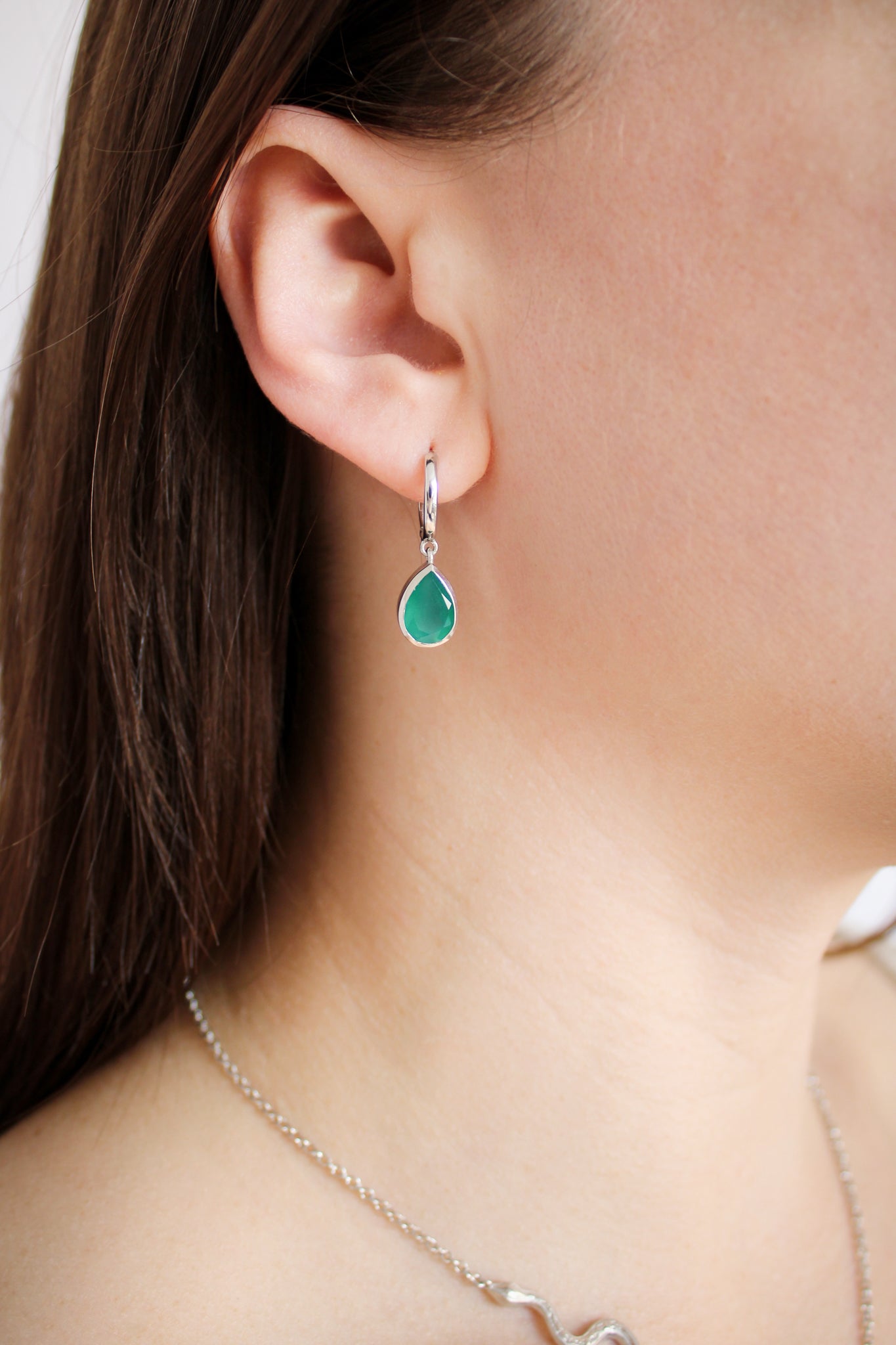 Devoted Earrings in sterling silver worn on model, green onyx teardrop huggie hoop earrings front view, Ether Jewelry