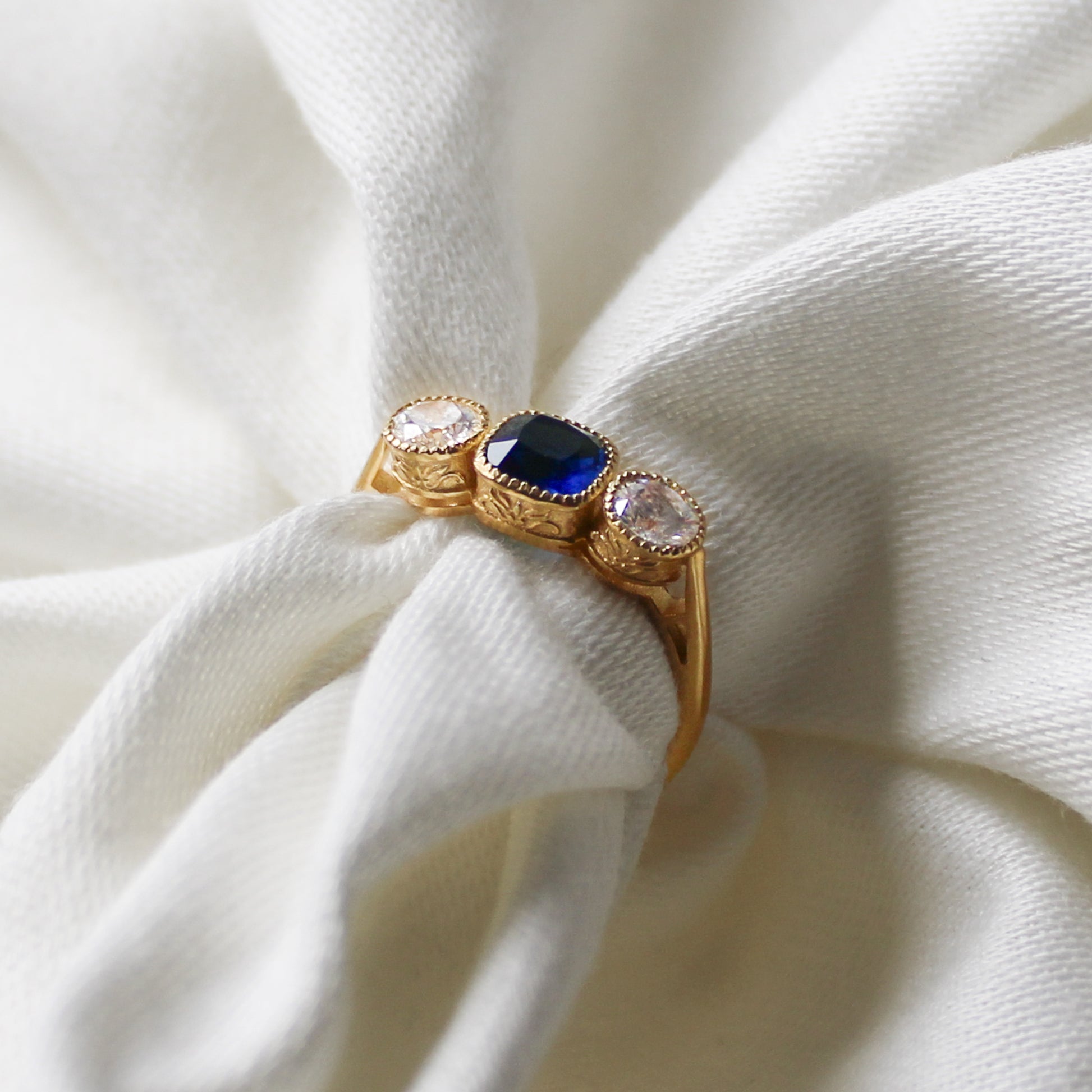 Edwardian Empress 18k gold vermeil ring wrapped around fabric showing filigree detail, blue CZ milgrain bezel ring, Ether Jewelry
