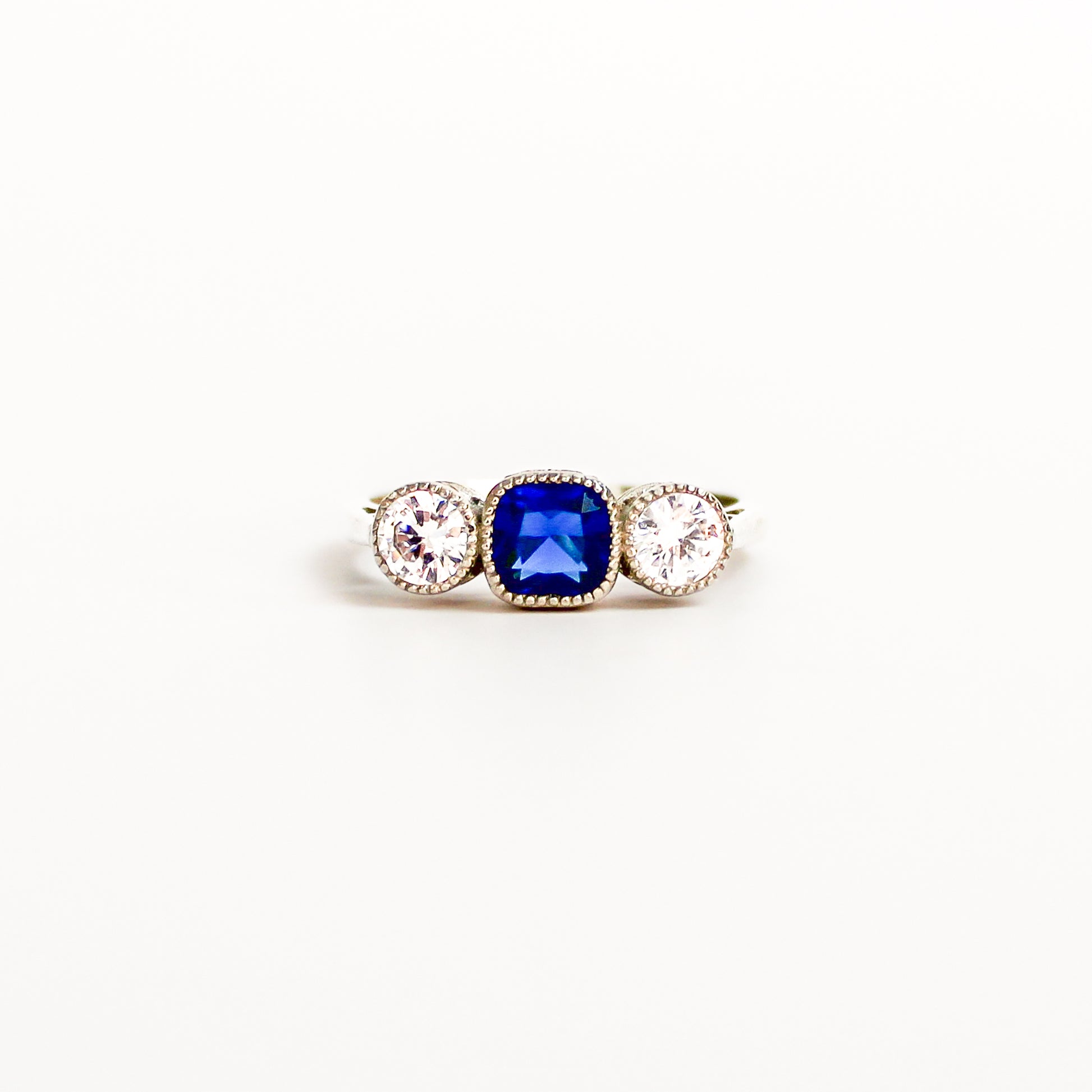 Edwardian Empress Ring sterling silver, blue sapphire gemstone, diamond accents, on white background, ether jewelry