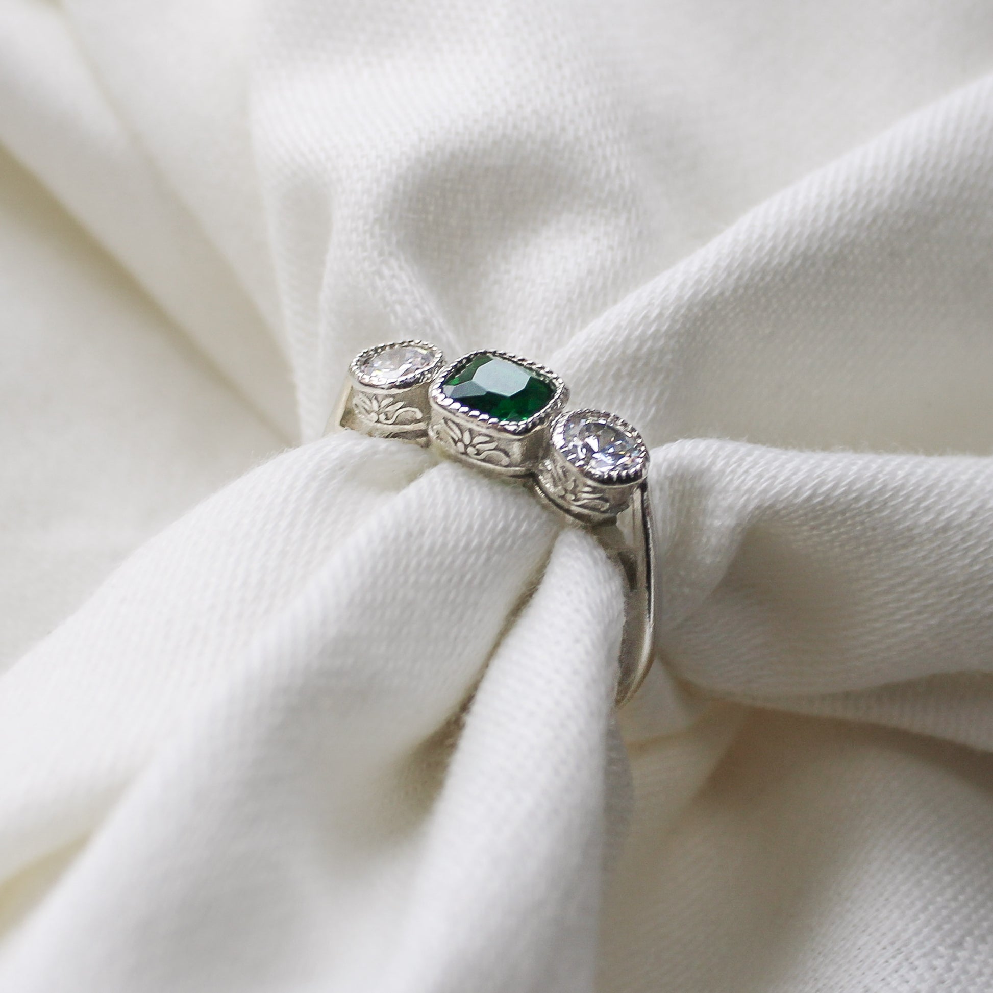 Edwardian Three Stone sterling silver ring wrapped around fabric showing filigree detail, green CZ milgrain bezel ring, Ether Jewelry