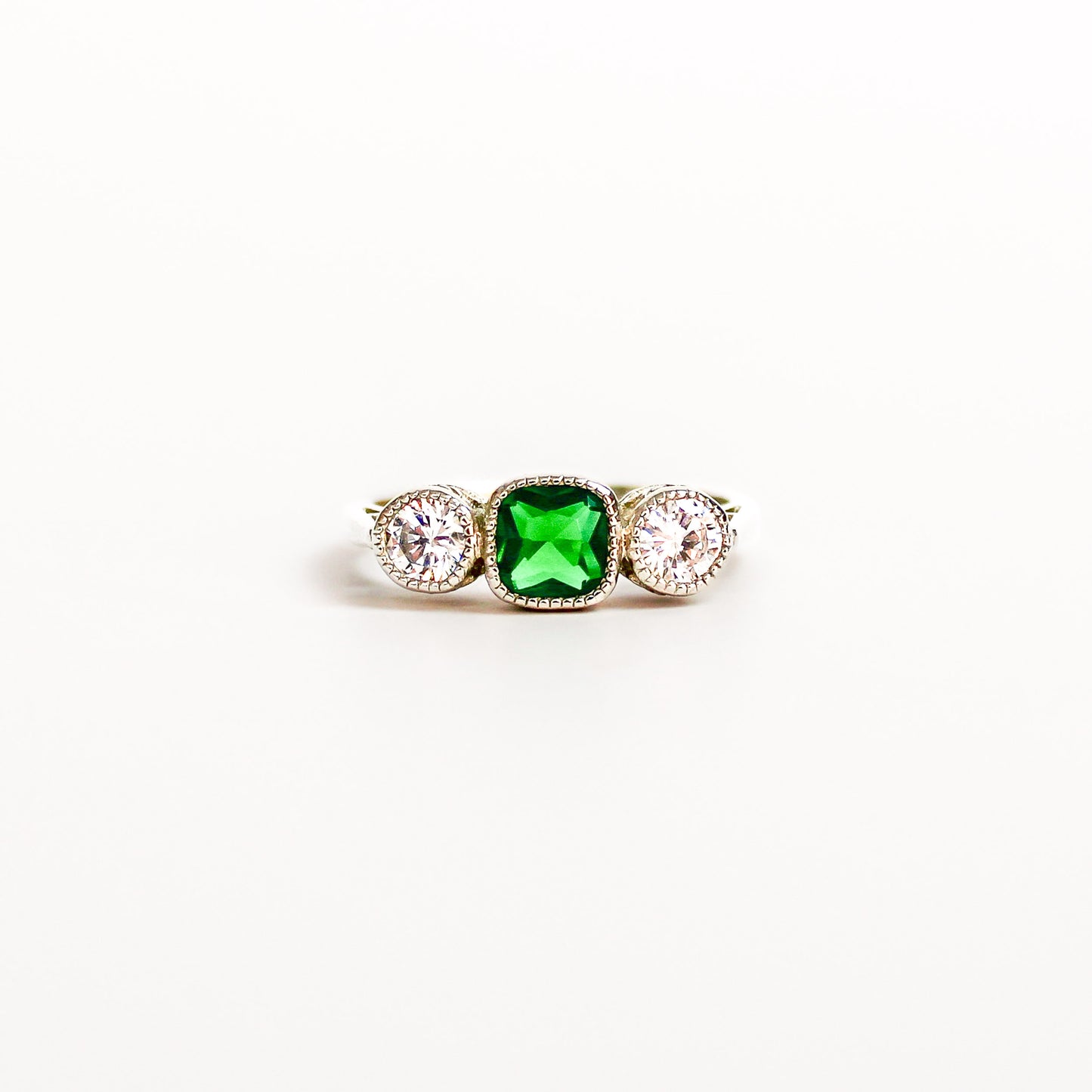 Edwardian Three Stone ring sterling silver, emerald and diamond, filigree detail, on white background, ether jewelry