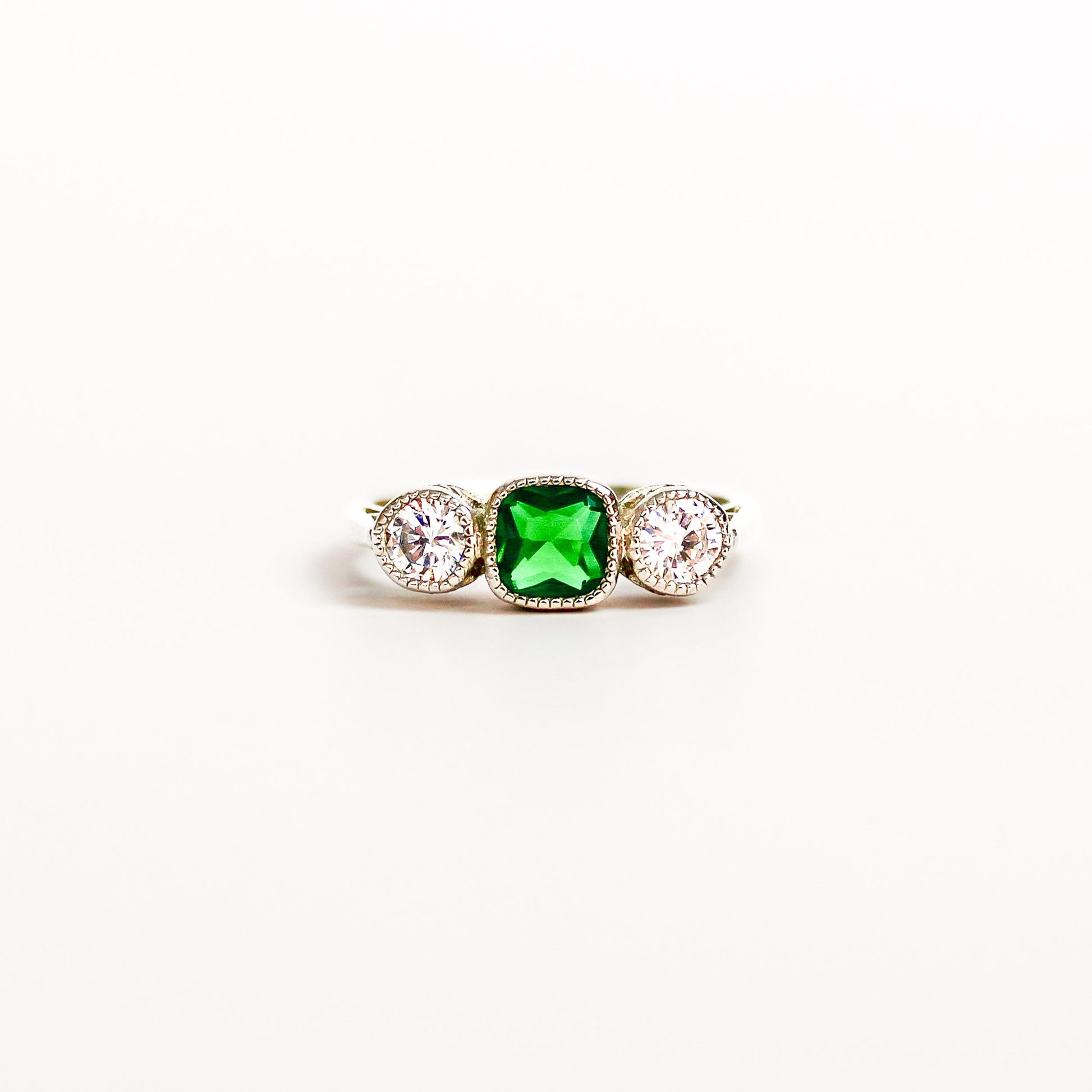 Edwardian Three Stone ring sterling silver, emerald and diamond, filigree detail, on white background, ether jewelry