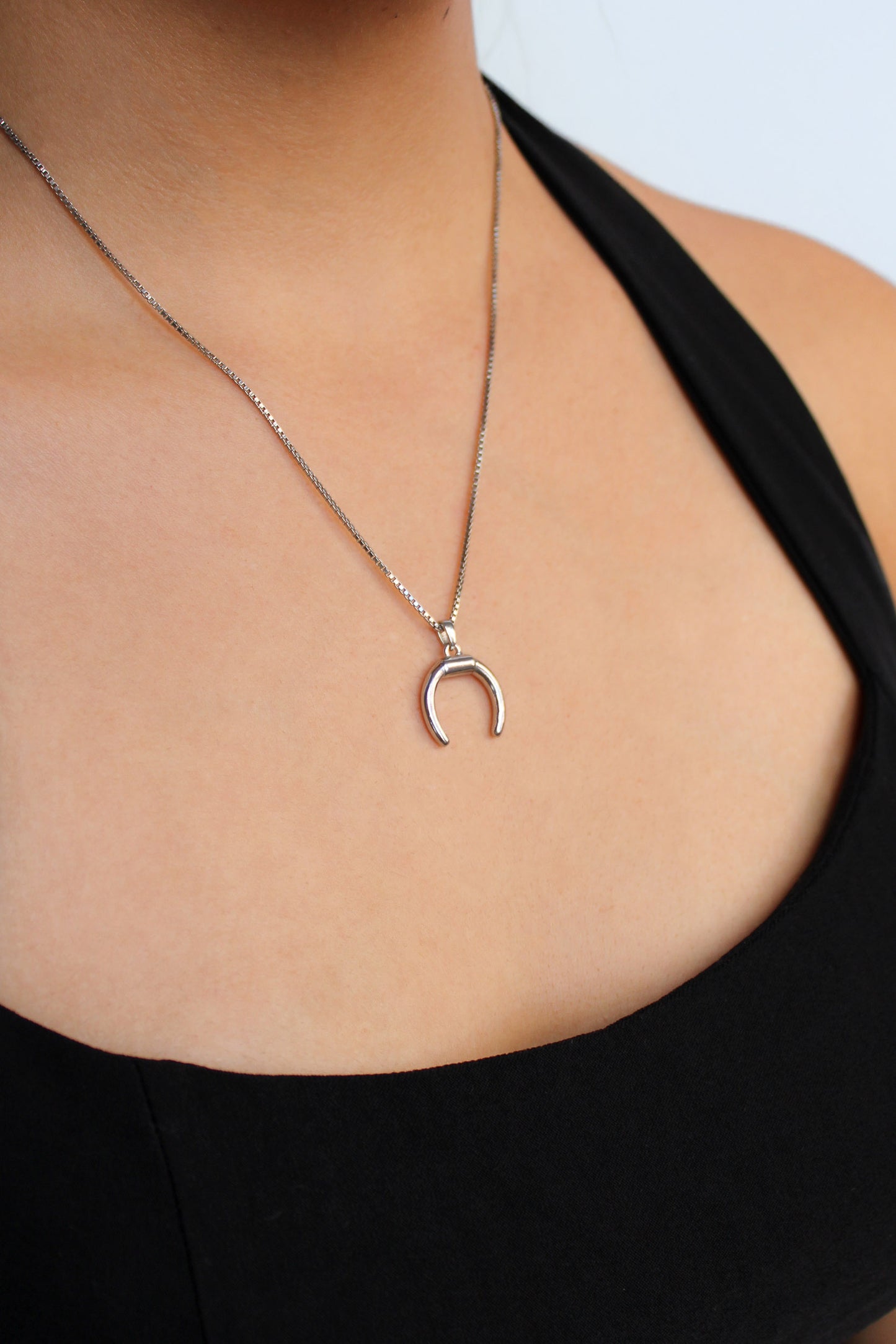 Ether Necklace in sterling silver worn by model, double horn crescent pendant close-up, Ether Jewelry