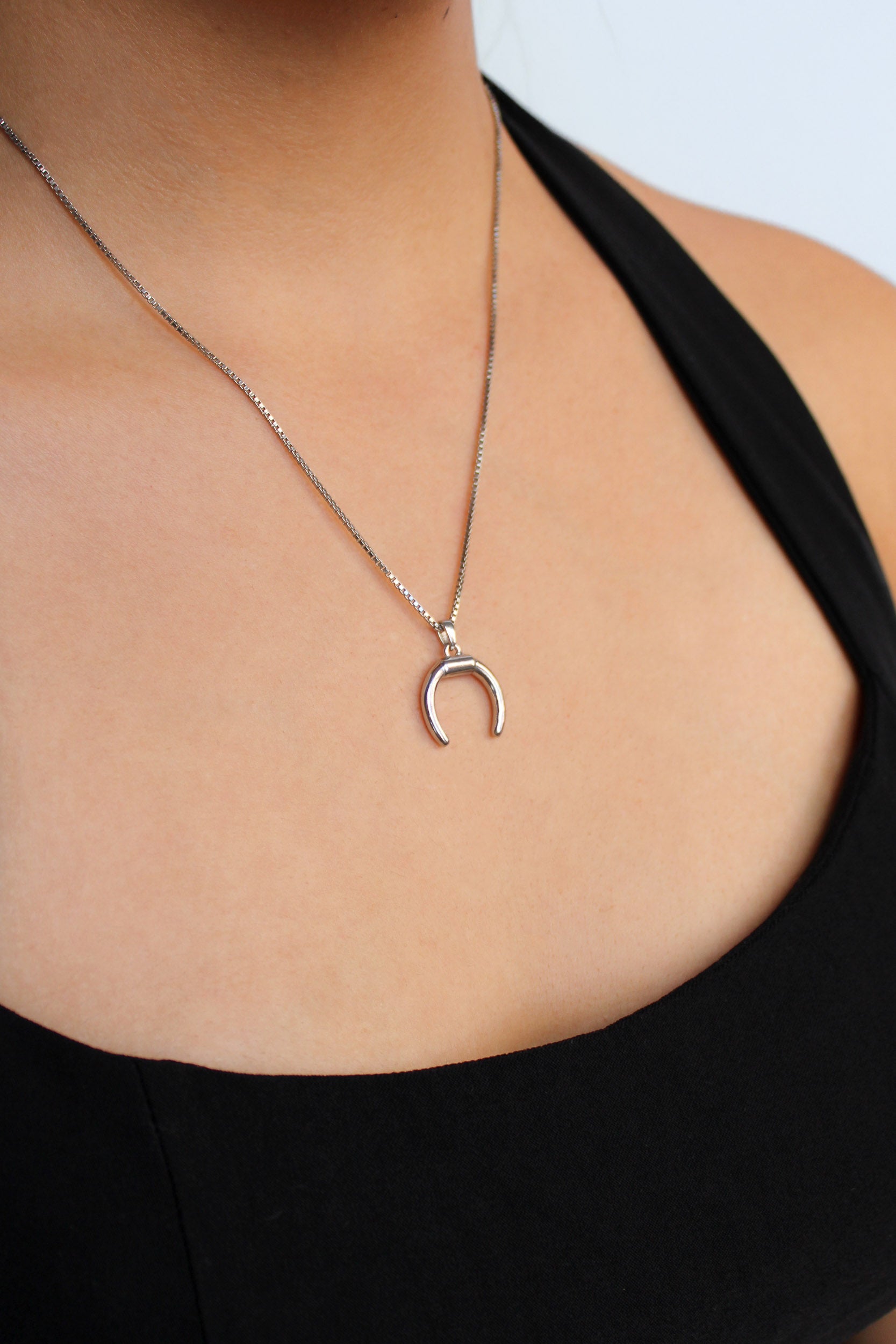 Ether Necklace in sterling silver worn by model, double horn crescent pendant close-up, Ether Jewelry