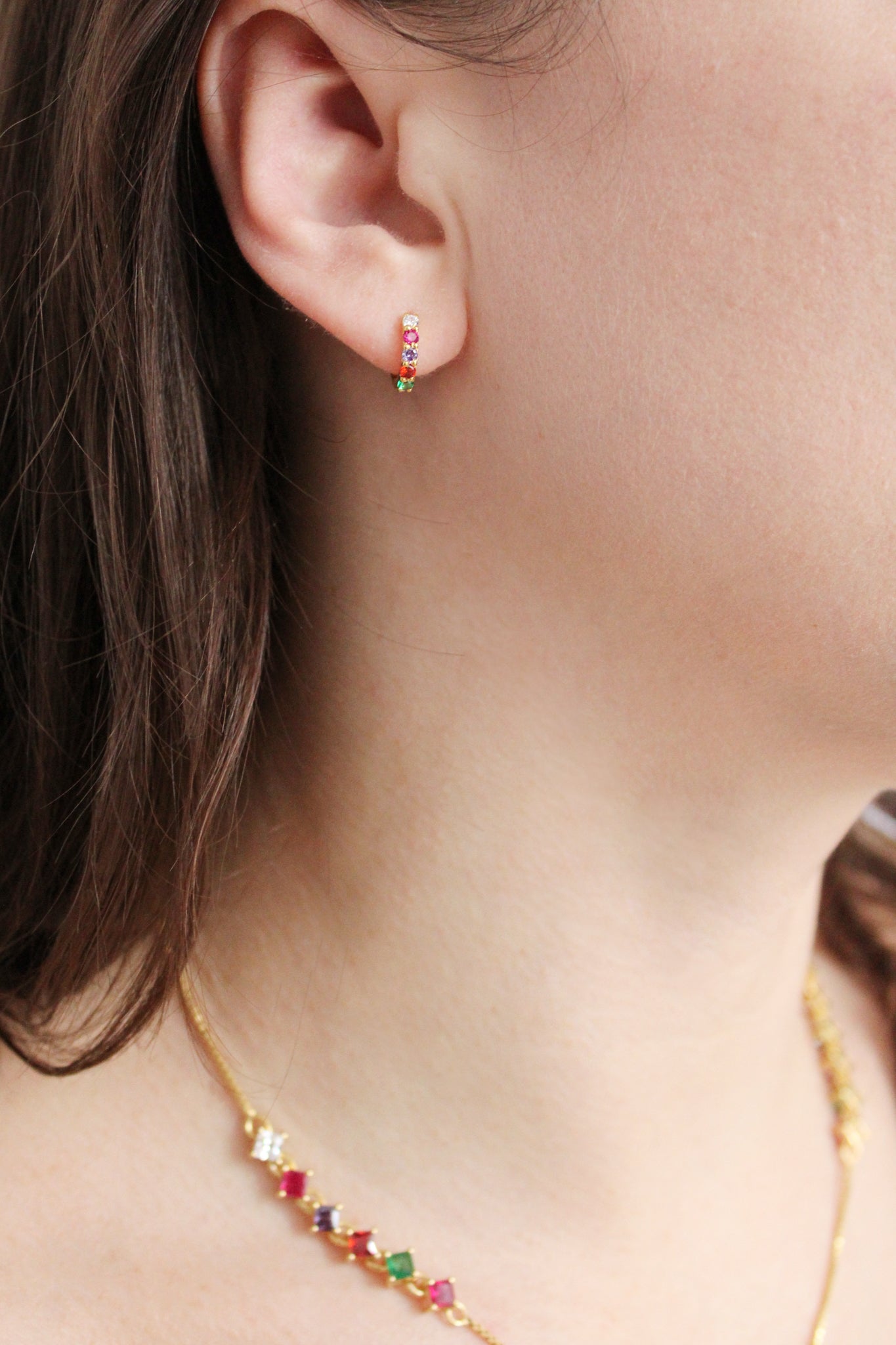 Regard Huggies 18k gold vermeil on model ear from another angle, acrostic CZ huggie hoop earrings, Ether Jewelry