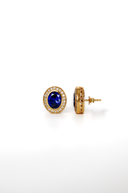 Gold Sovereign Stud Earrings with sapphire-toned center stones and radiant white halos inspired by Princess Diana.