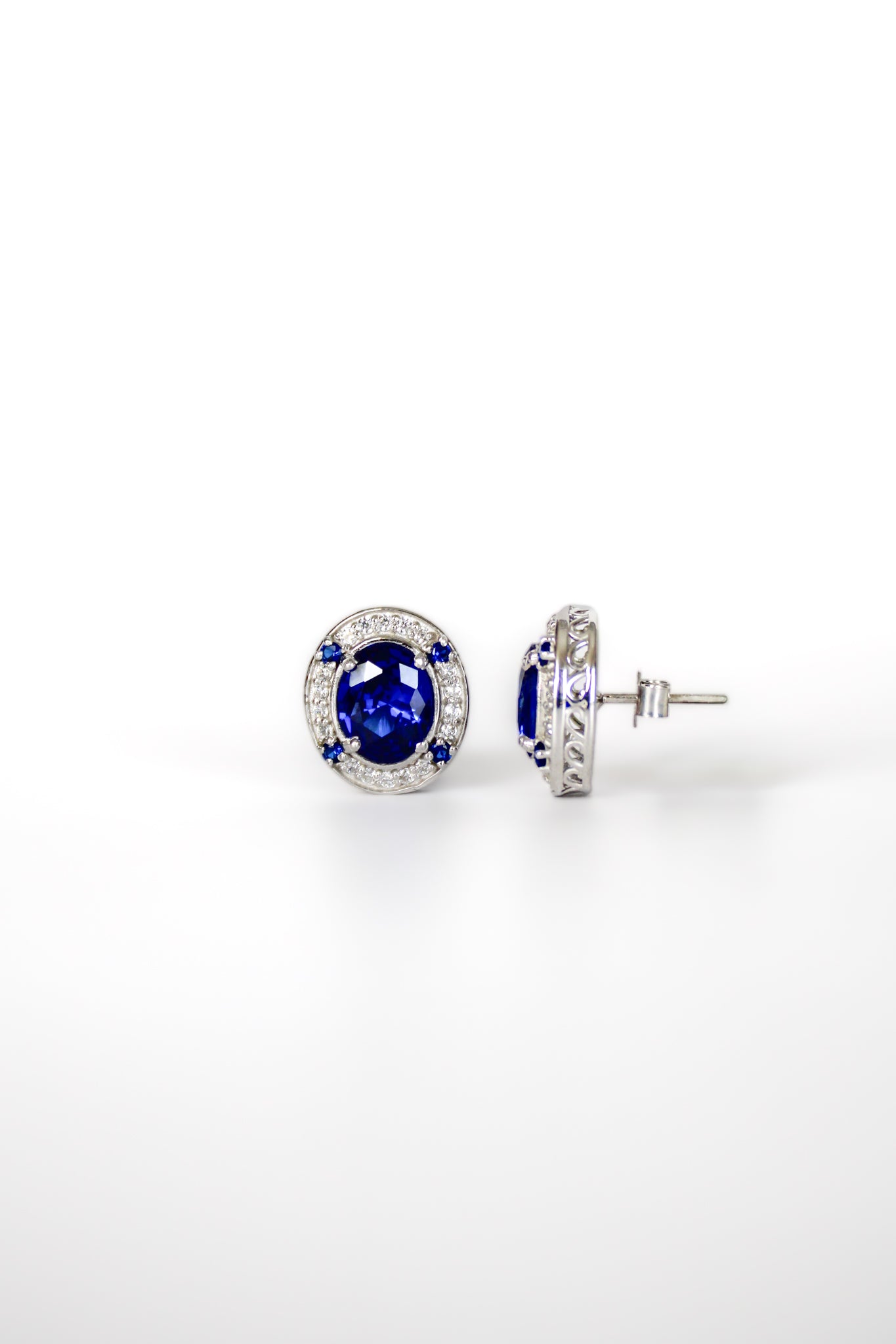 Sterling silver Sovereign Stud Earrings with sapphire-toned centers and halos of white stones.