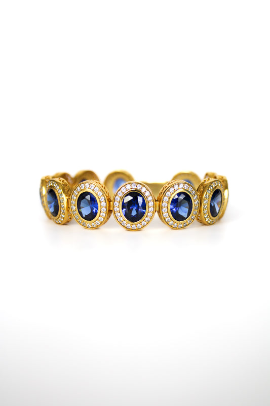 Gold Halo Bracelet with sapphire-toned and white gemstones forming radiant stations inspired by Princess Diana.