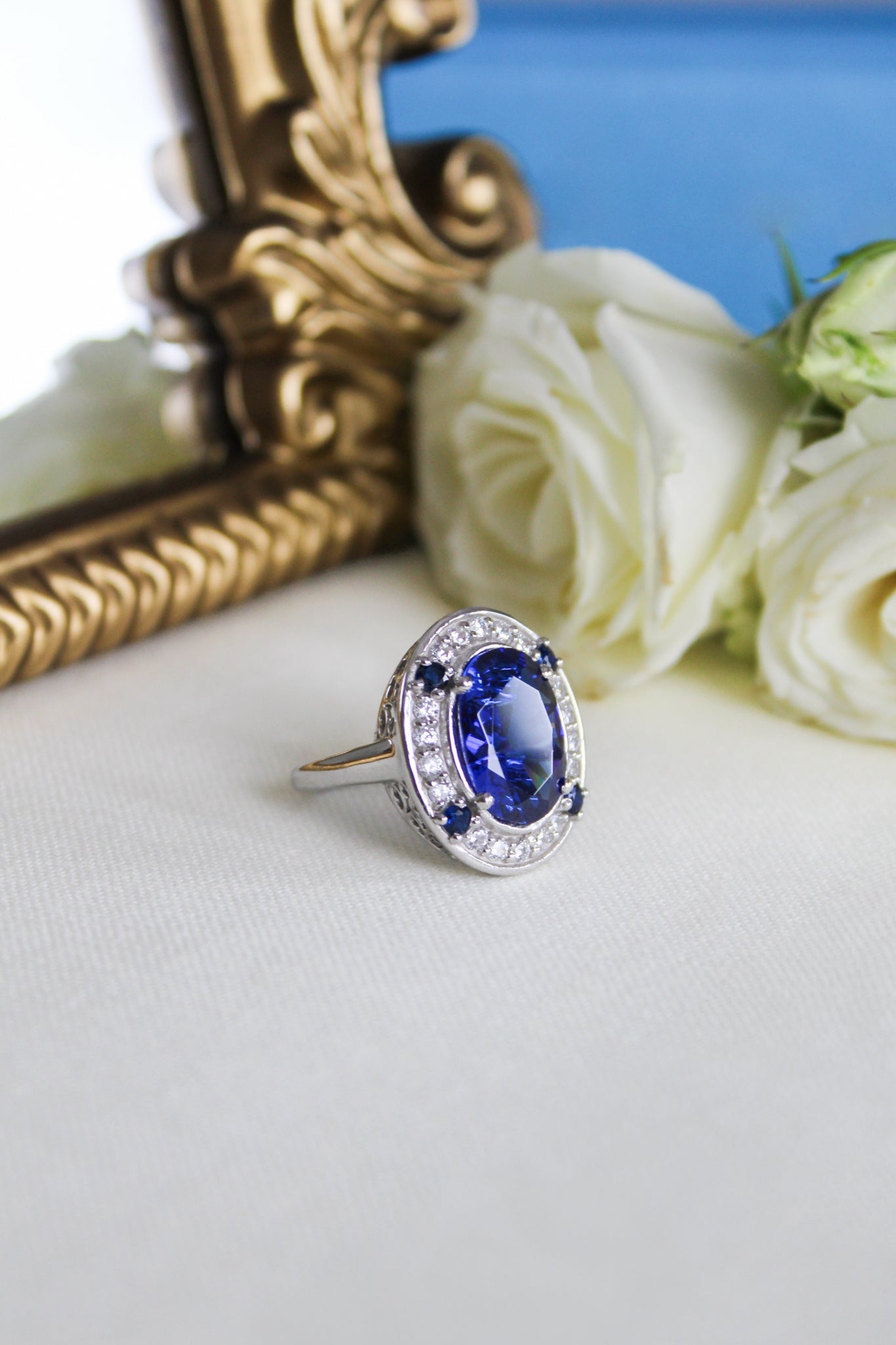 Close-up of silver Diana Legacy Ring with luminous blue center stone and engraved gallery details.