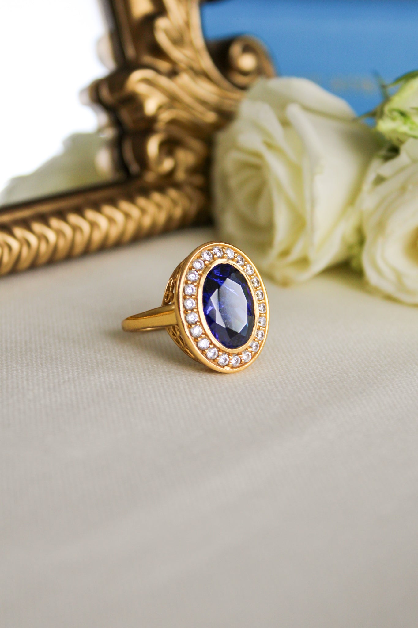 Gold Diana Legacy Ring featuring sapphire-blue center stone surrounded by brilliant white accents on engraved band, Ether Jewelry