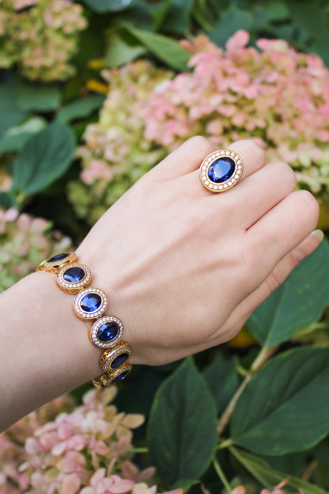 Model wearing The Legacy Ring in gold vermeil with sapphire-toned center gemstone catching warm light — inspired by Princess Diana’s timeless grace.