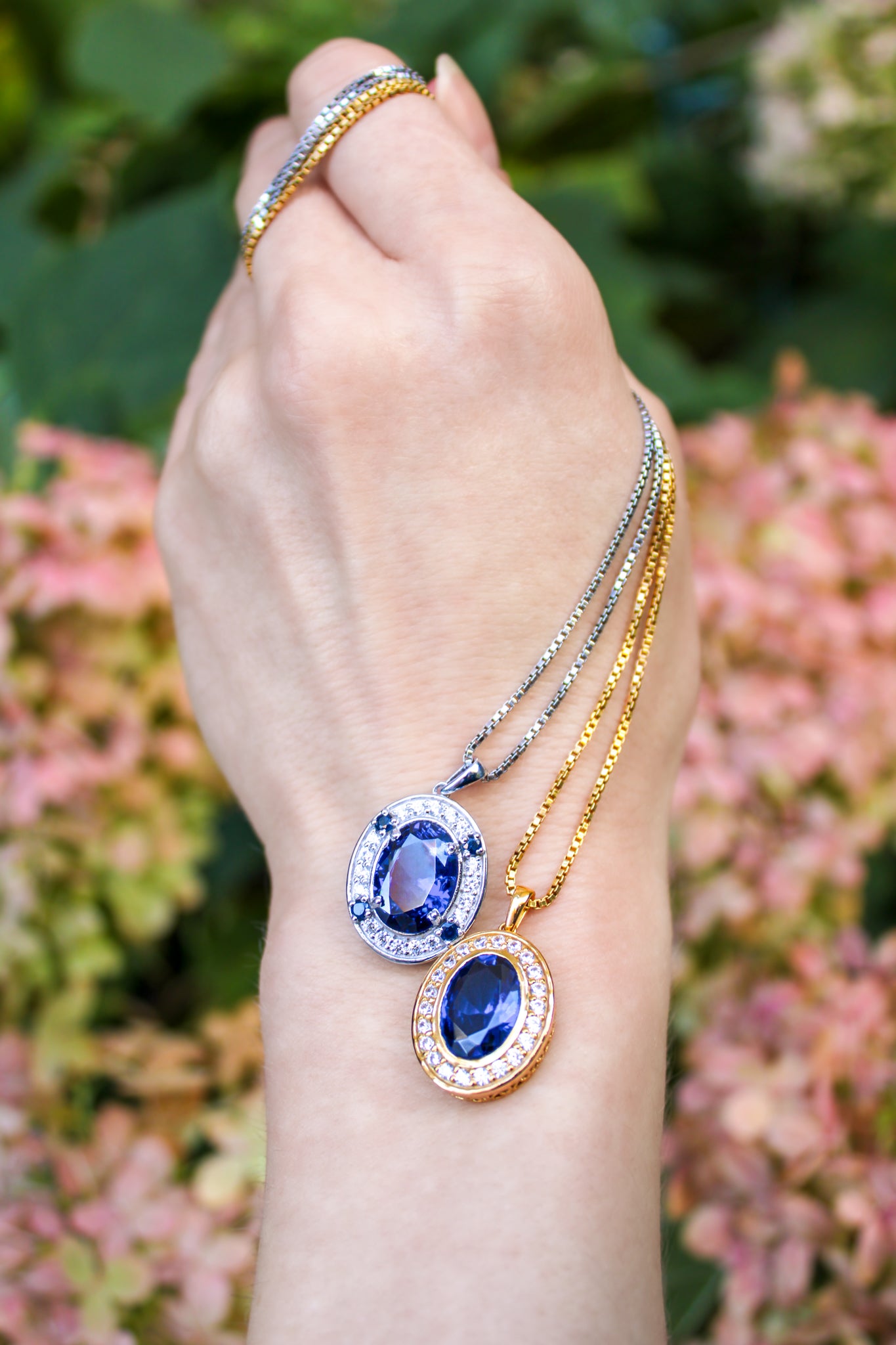Gold Heartline Necklace detail shot showing sapphire gemstone surrounded by luminous white stones.