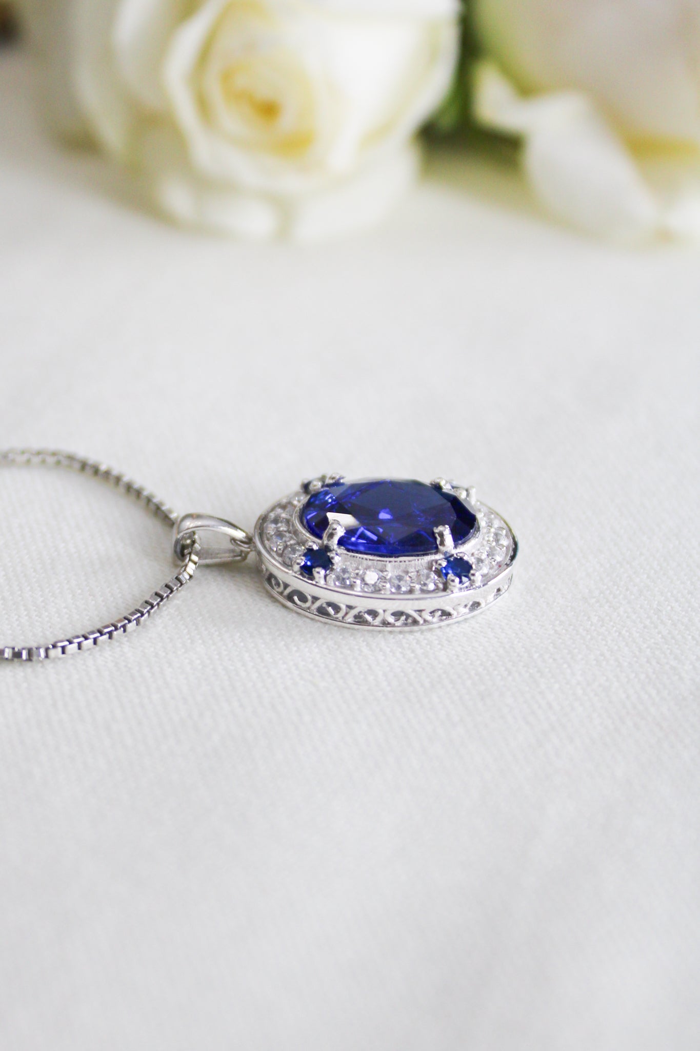 Detailed macro of silver Heartline Necklace showing radiant blue gemstone and engraved gallery setting, Ether Jewelry