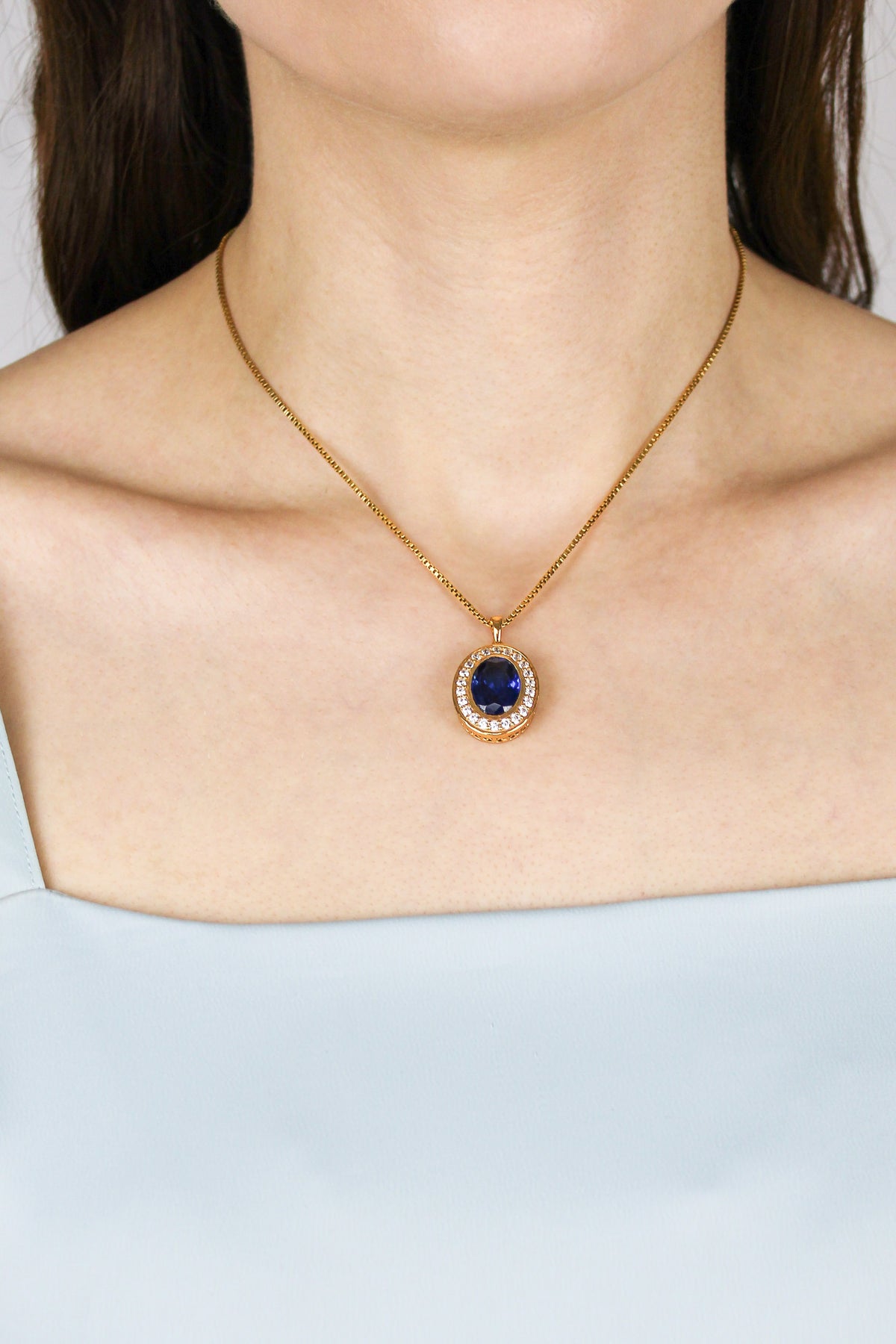 Close-up of model’s neckline showcasing gold Heartline Necklace, sapphire gemstone symbolizing eternal love, Ether Jewelry