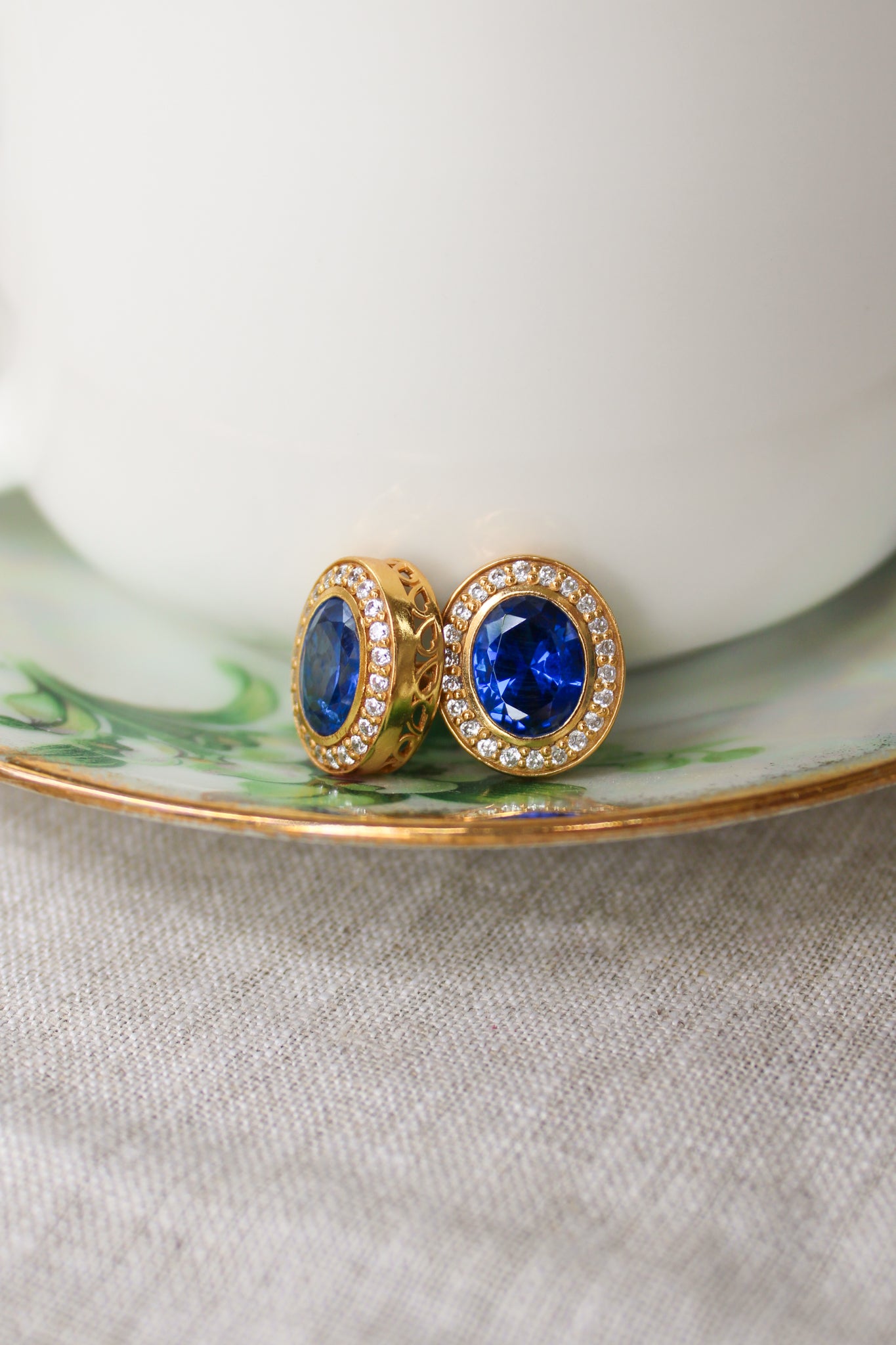 Detailed macro of gold Sovereign Stud Earrings showing intricate halo design and regal craftsmanship.