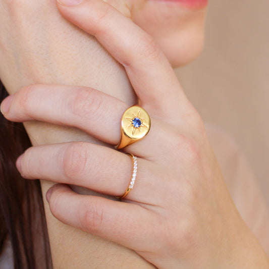 Wayfinder Ring in 18k gold vermeil on model holding hands close to face, engraved north star signet ring with blue CZ, Ether Jewelry