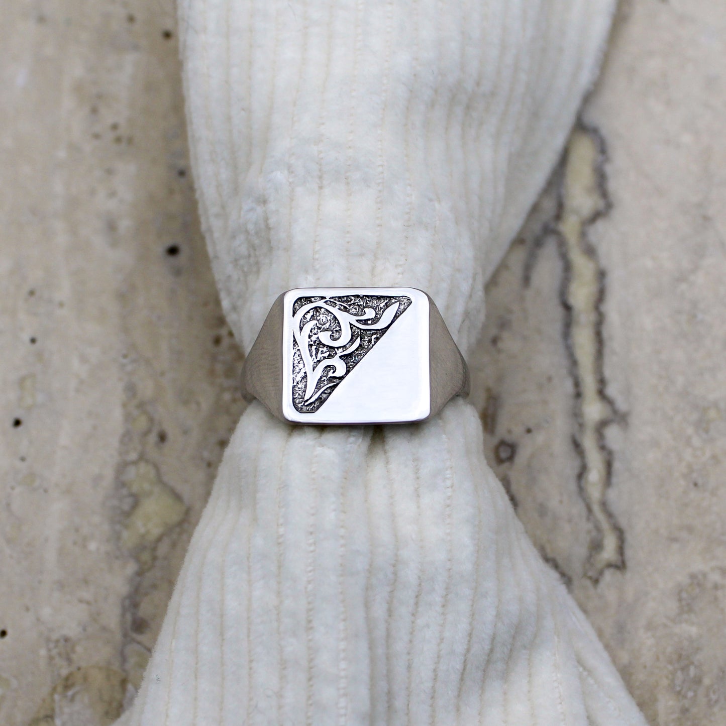 sterling Silver architect square signet ring with intricate design on a white knitted fabric against marble background