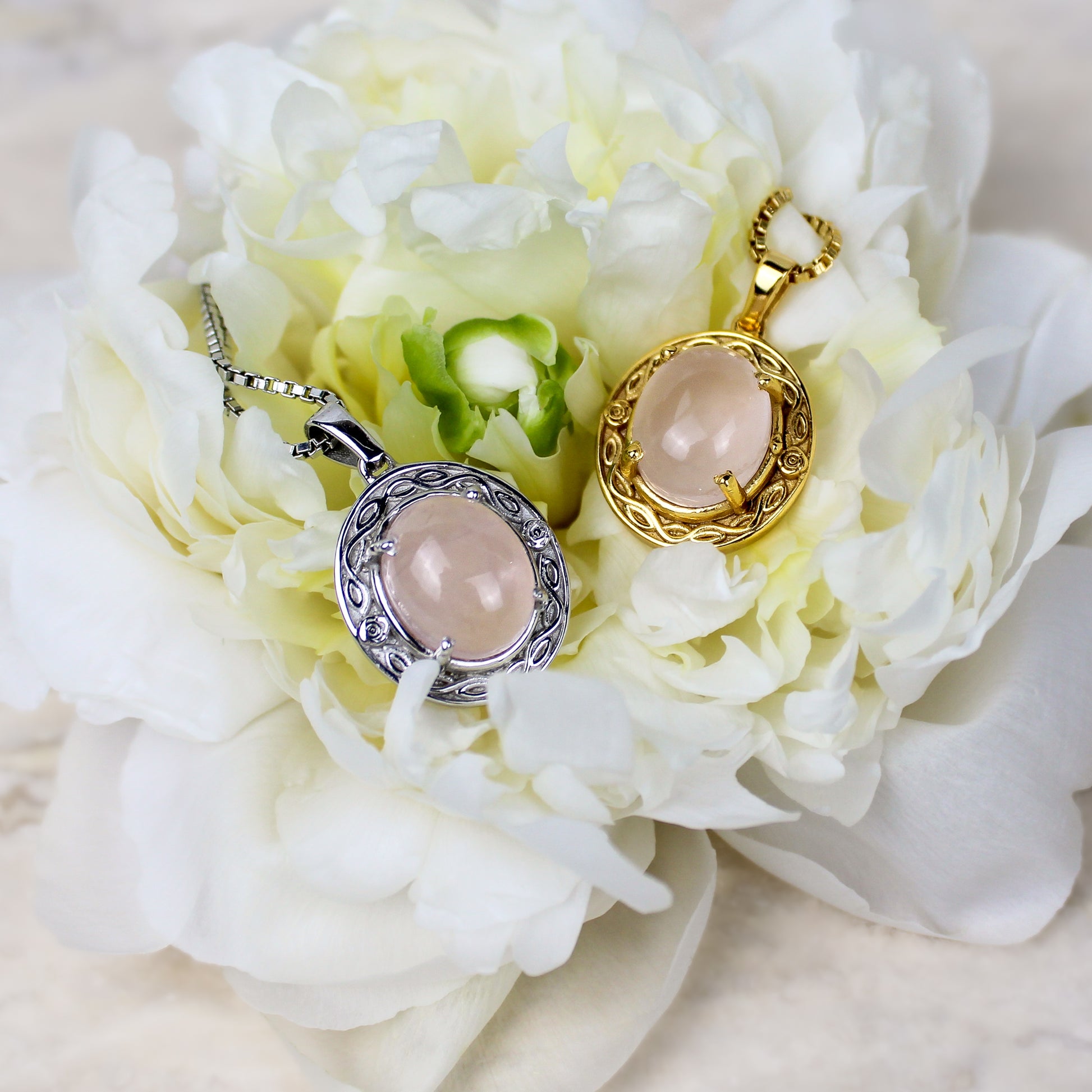 Two Romantic Heir pendants with pink quartz stones on a bed of white flowers