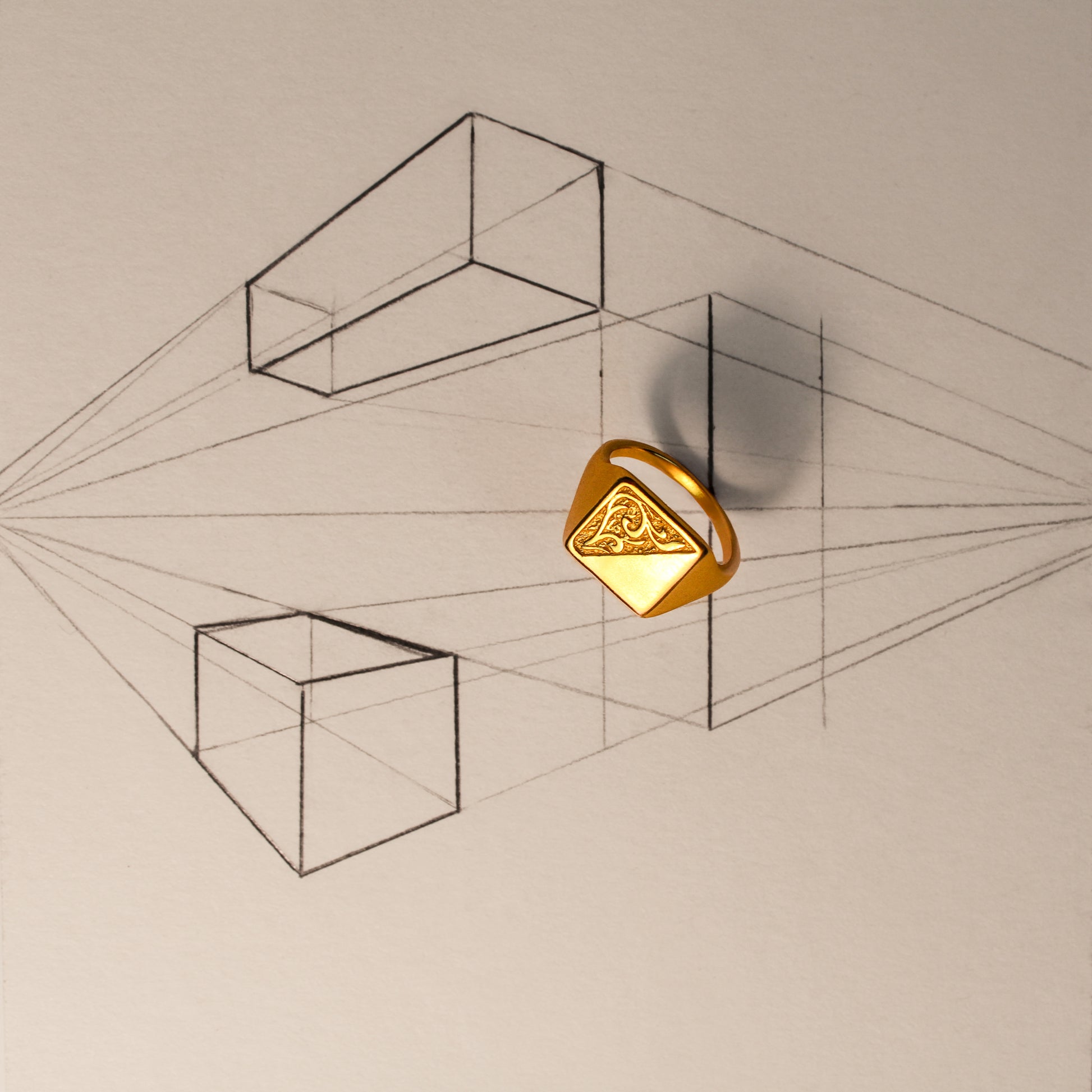Gold geometric signet ring on a background with architect sketch of line art of cubes