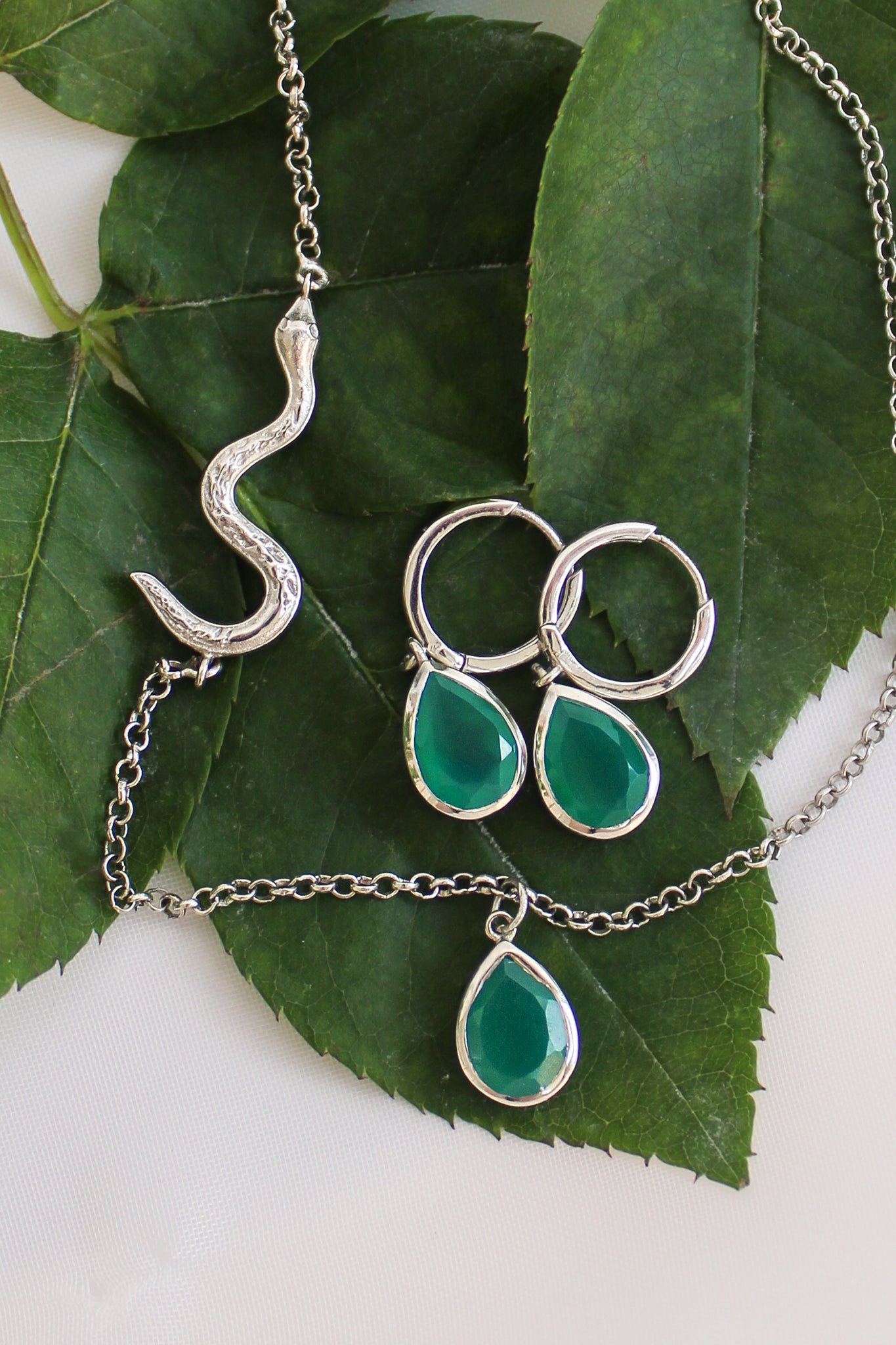 Devoted sterling silver earrings staged on leaf with Devoted Necklace, green onyx serpent jewelry set, Ether Jewelry