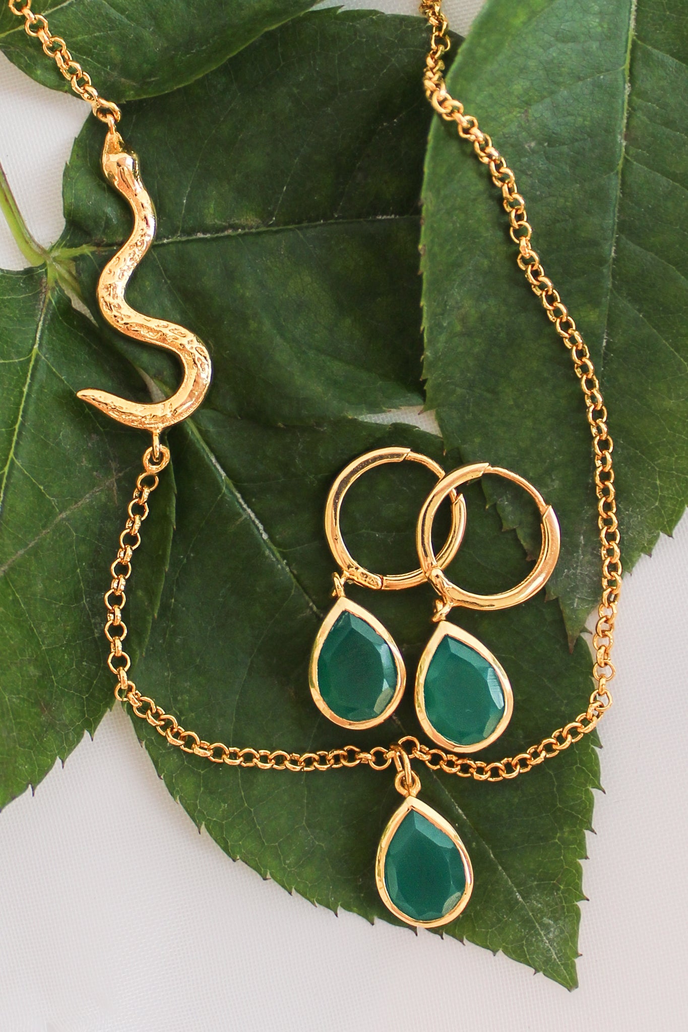 Devoted 18k gold vermeil earrings staged on leaf with Devoted Necklace, green onyx serpent jewelry set, Ether Jewelry