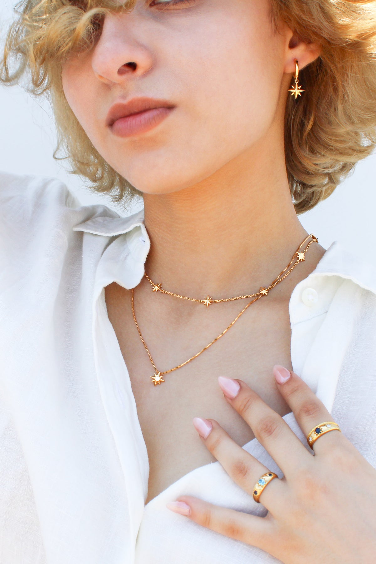 Juno Necklace in 18k gold vermeil on model styled with matching necklace and earrings, multi north star charm station necklace, Ether Jewelry