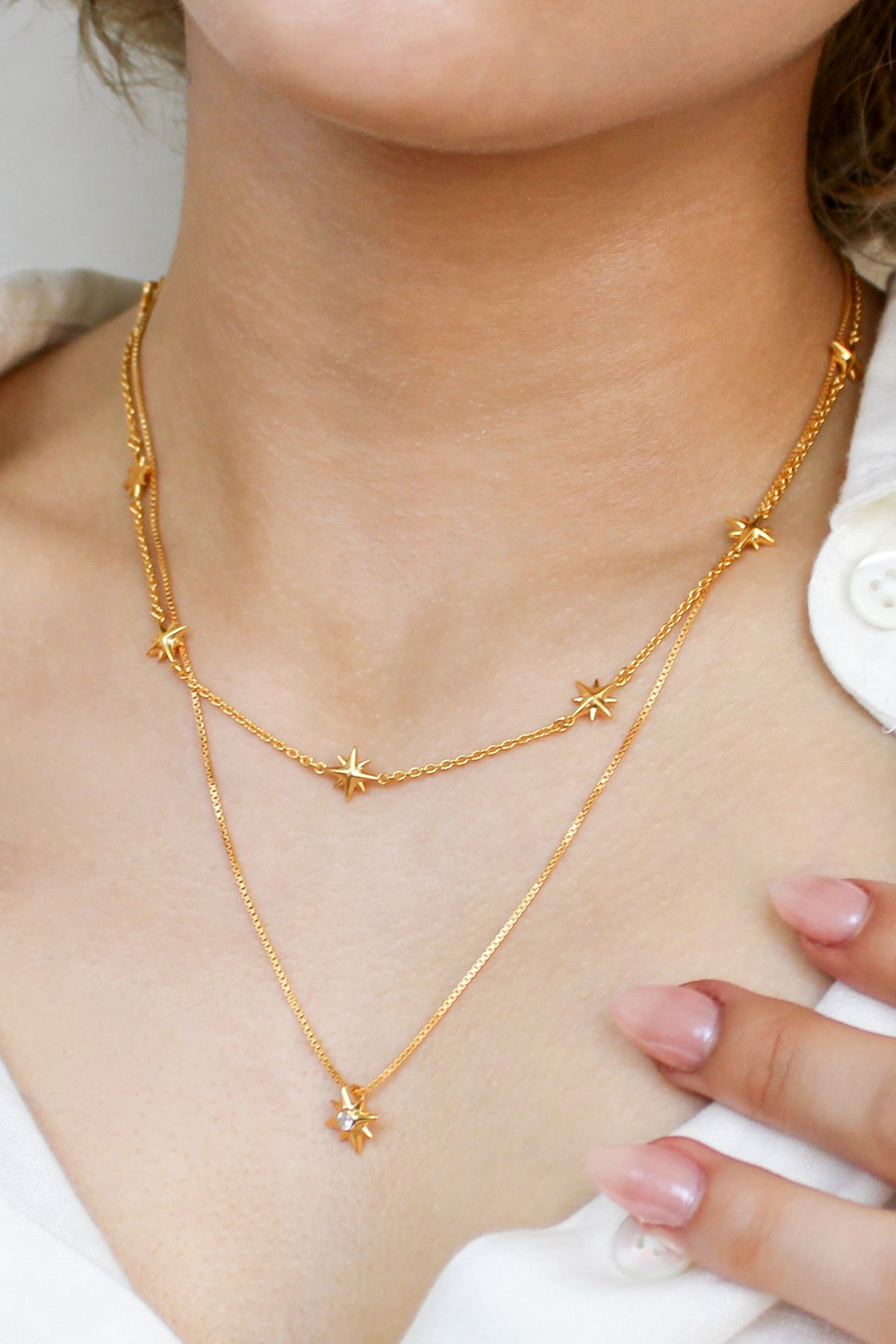 Juno Necklace in 18k gold vermeil on model styled with matching jewelry, multi north star charm station necklace, Ether Jewelry
