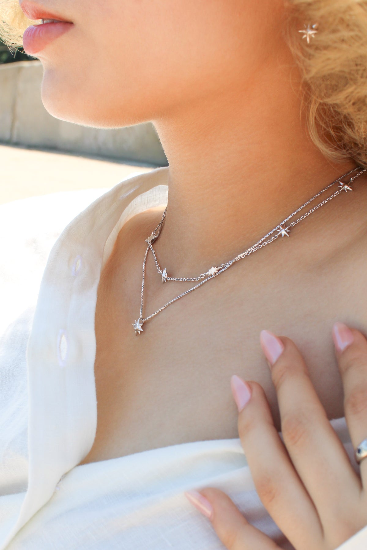 Juno Necklace in sterling silver on model side view with north star earrings and lucida necklace, scattered star charm necklace, Ether Jewelry