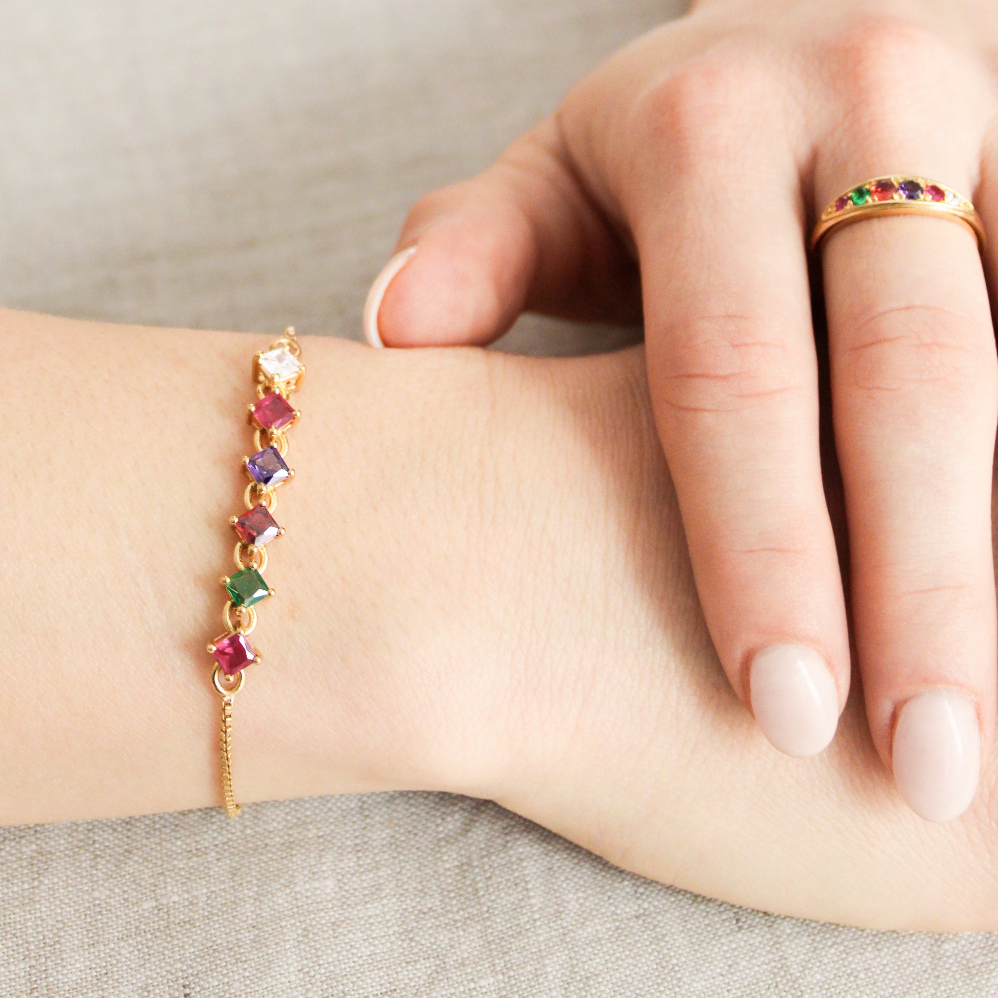 Linked Love 18k gold vermeil bracelet on model hands crossed on table with matching necklace and Regard ring, acrostic jewelry set, Ether Jewelry